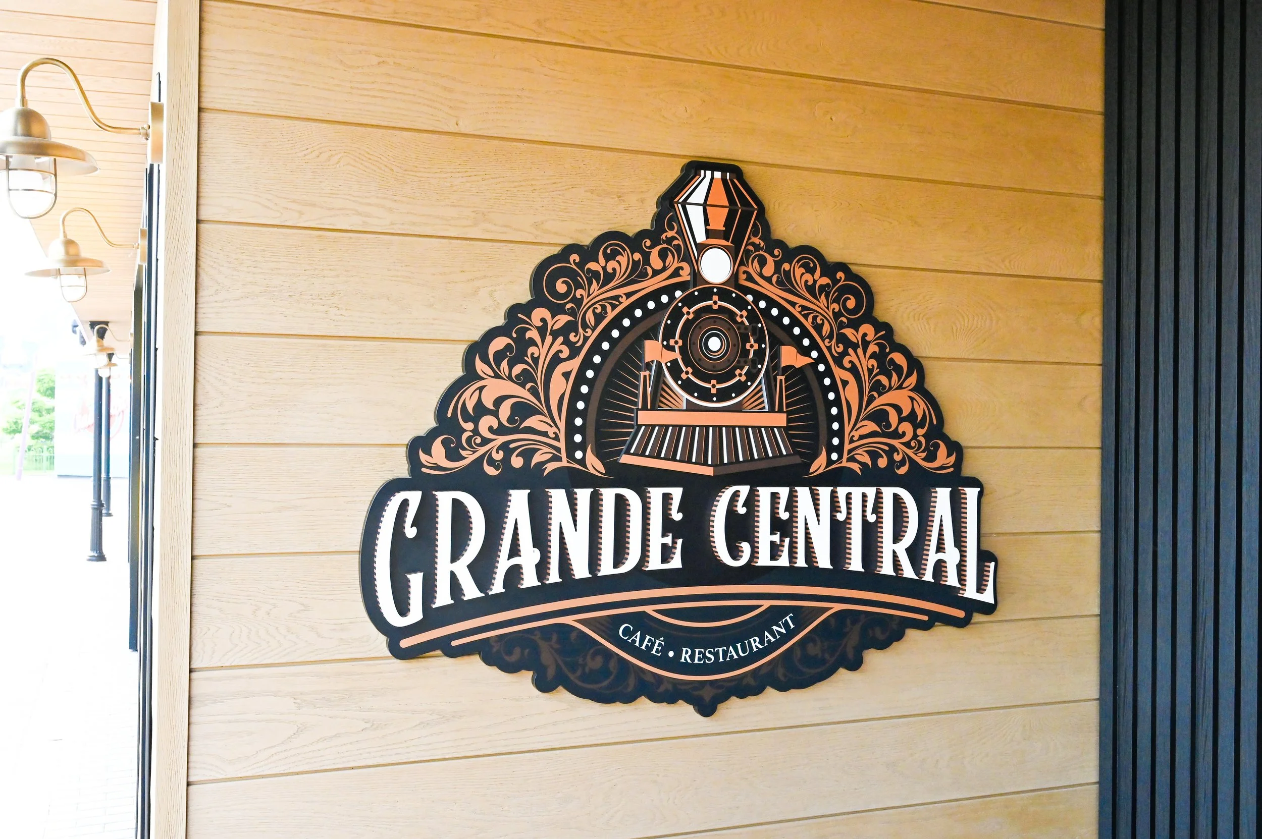 Logo sign for Paultons Park's cafe restaurant grande central featuring art deco stylised train illustration.