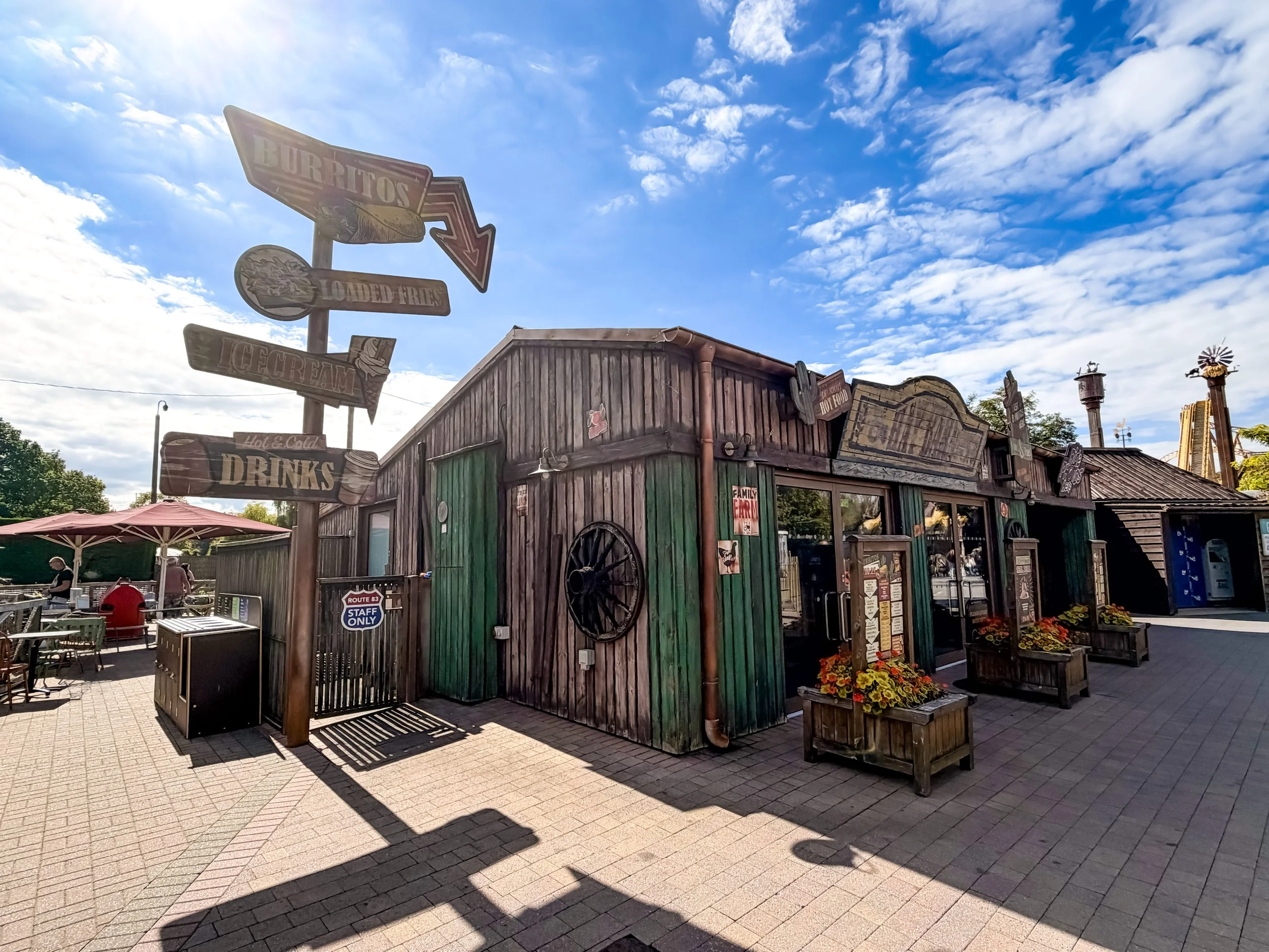 photo of hay barn food kiosk - wooden rustic building with large wooden signage with burritos, fries and ice creams