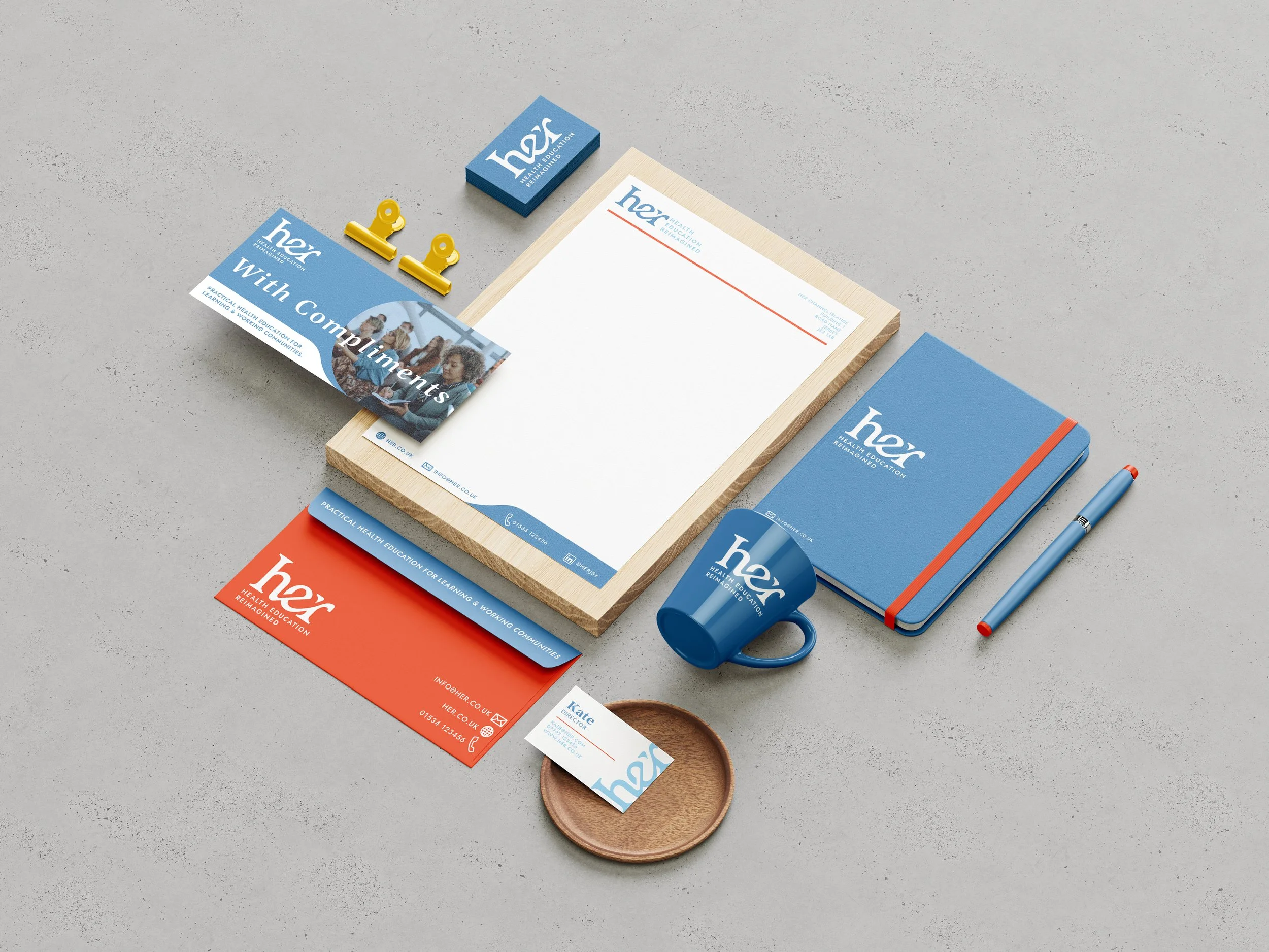 Smart corporate branded stationery with blue and red accents featuring letterhead, business card, compliment slip, mug, notebook, pen and clips