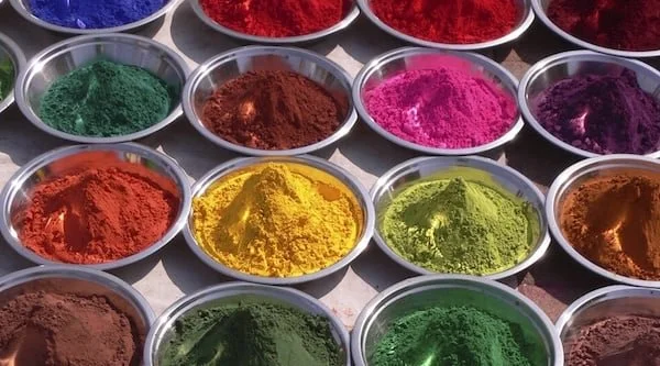 Bowels of powdered colored pigments including green, red, pink, purple, orange, yellow, and brown.