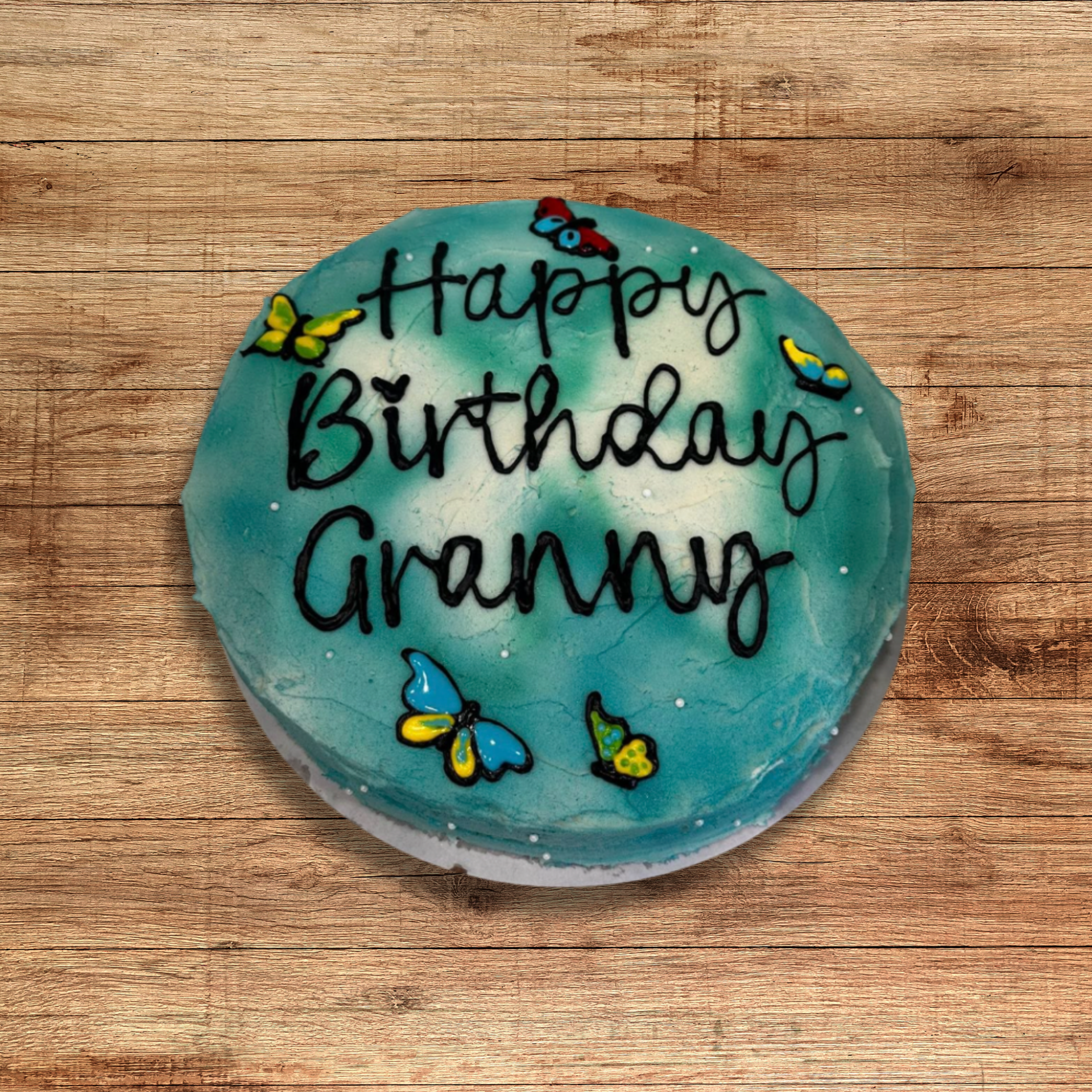 Simple designed birthday cake with ombre blue icing and butterflies.