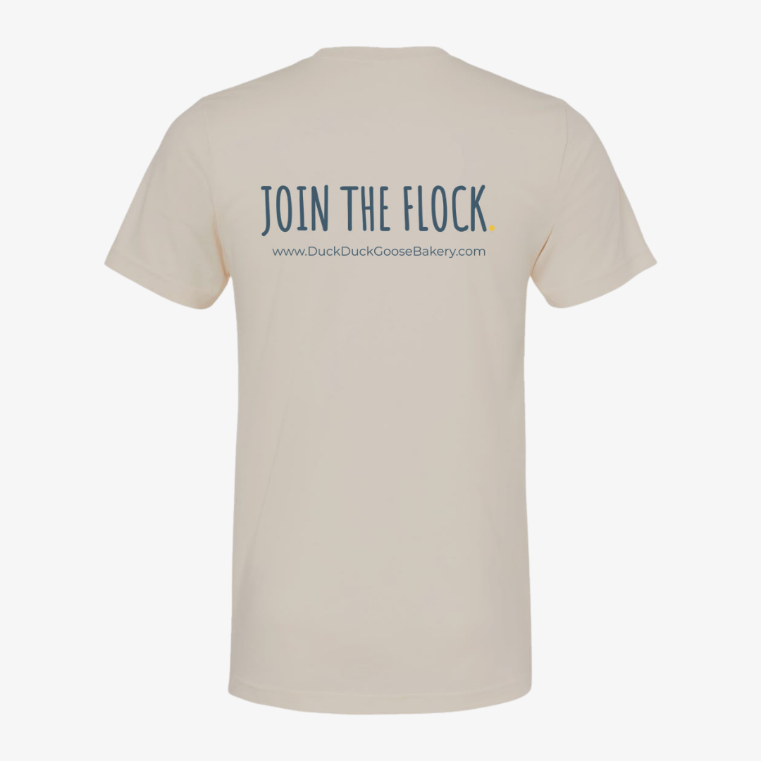 Duck Duck Goose Bakery tshirt with logo in middle of tan t-shirt.