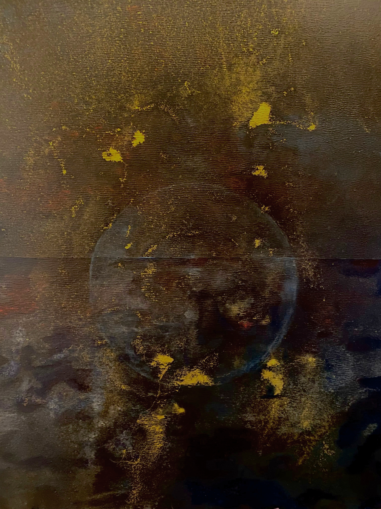 this is a picture of a painting with dark backround and golden splashes, an earth or bubble flowing in the middle.