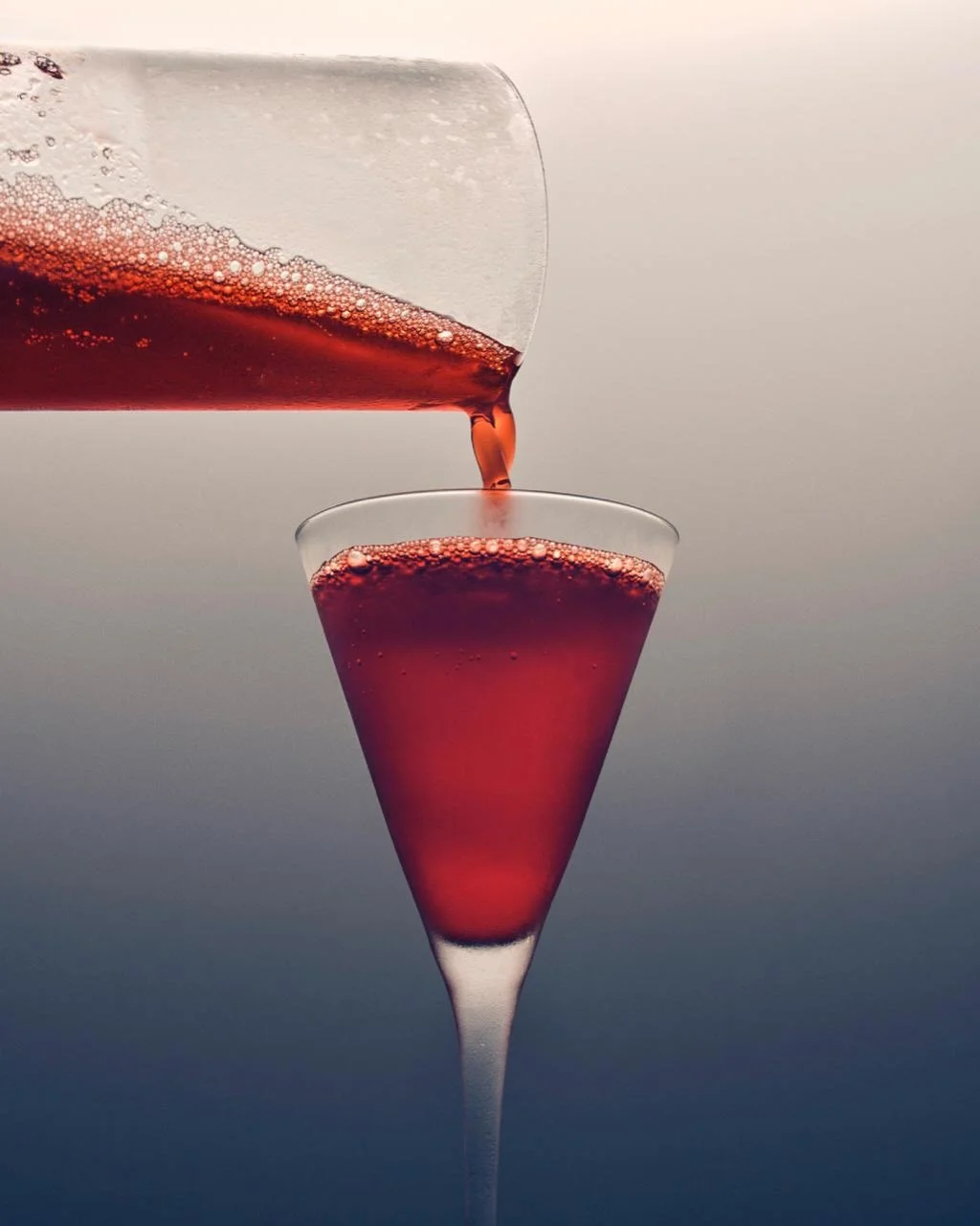 THE COLOUR OF TENSION.

A ribbon of scarlet enters the cold.

Tiny bubbles gather at the rim. Light passes through the glass, then disappears into depth.

Clean lines. Saturated colour. A composition balanced on its finest edge.

First, the pour.
The