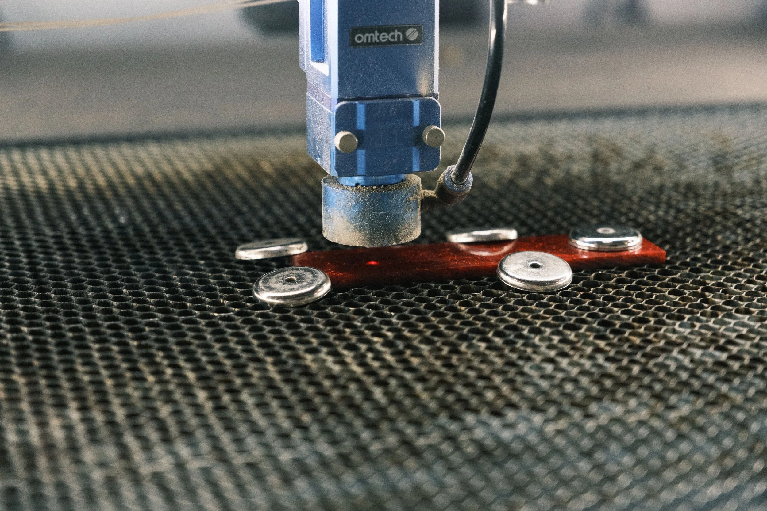   They use magnets to keep the material from shifting while the laser is cutting.  