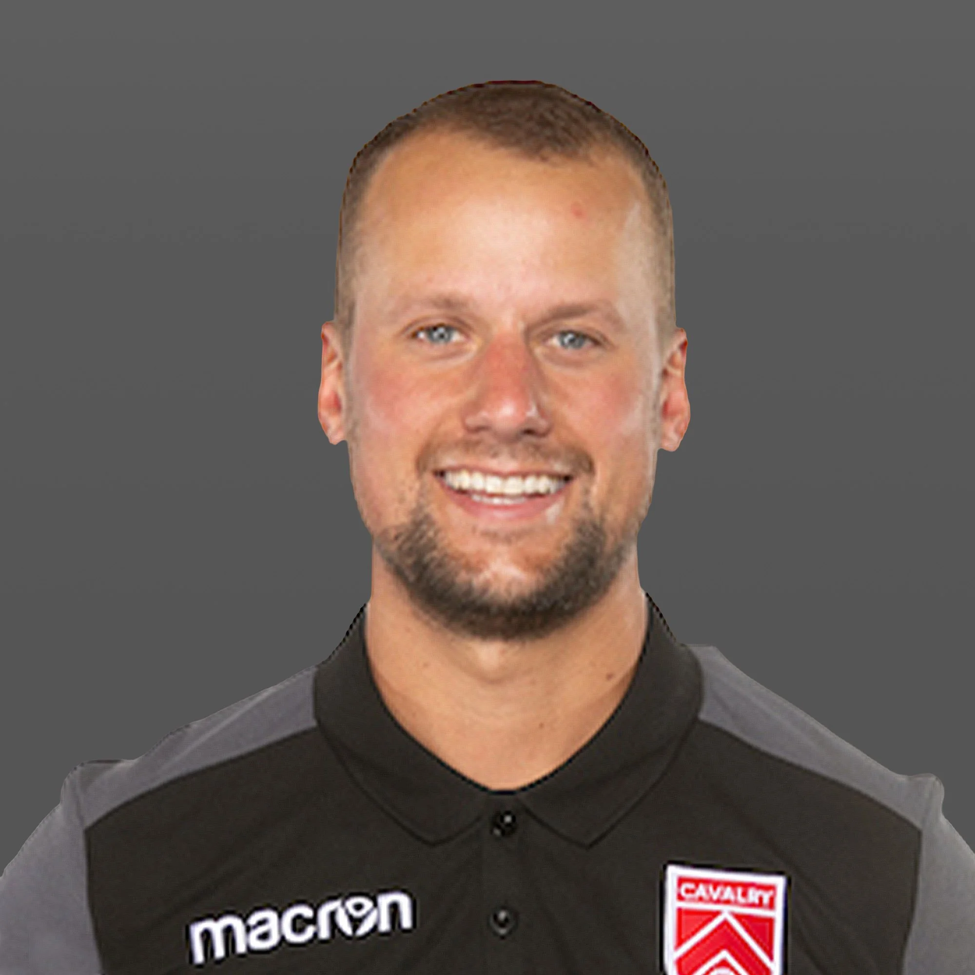 Portrait of a young man at night on a sports field, with blurred lights in the background.