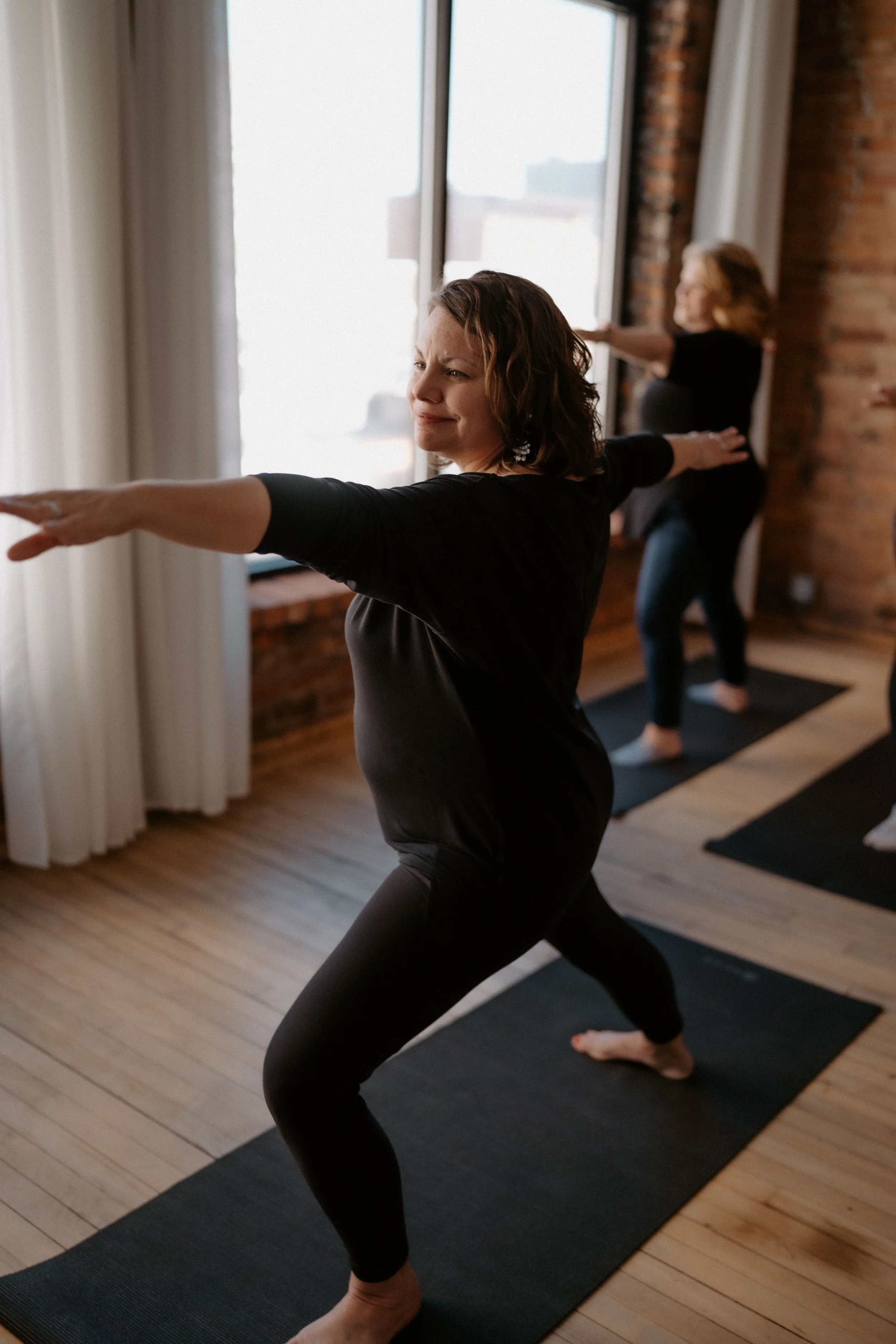 Two people practicing trauma informed yoga Brighton MI