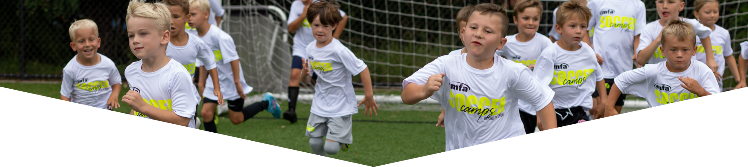 Children in white soccer jerseys running on a soccer field