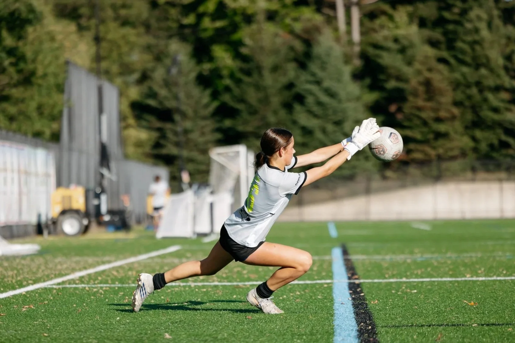 Teenage soccer goalie diving to save the soccer ball at goalkeeping camp in grand rapids michigan