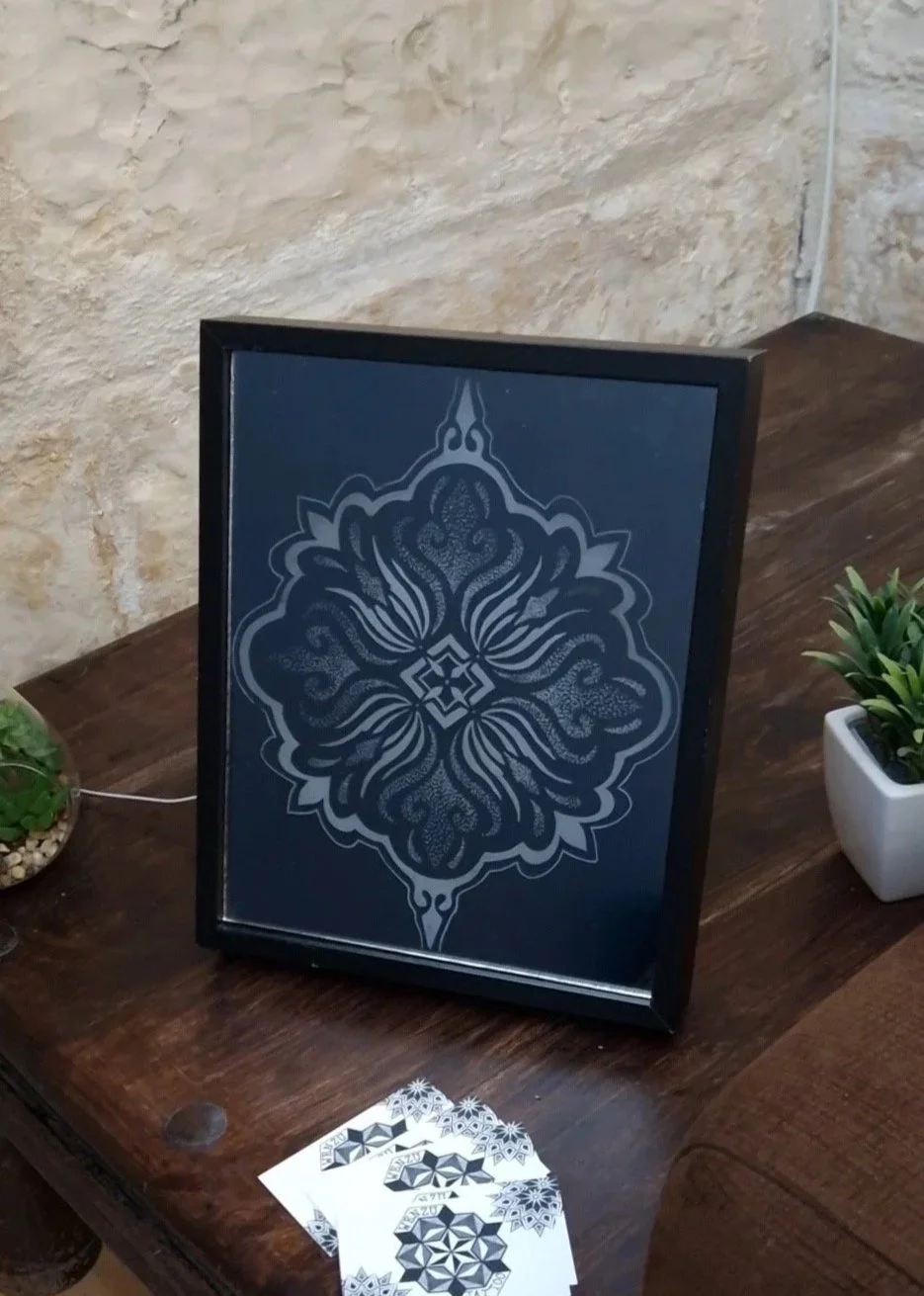CARVED IN GLASS

From my tattoo flash book to a glowing mirror. This mandala is engraved on the back of a mirror, lit from behind with LEDs so the etched lines glow. A technique I used years ago — but never like this. Feels good as an artist to creat