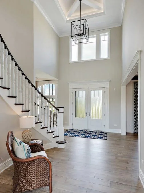 A sunlit, high-ceiling home entryway with modern architectural details, representing the successful "entry" into a new home managed with the technical precision and diligent due diligence of Monica O'Keefe.