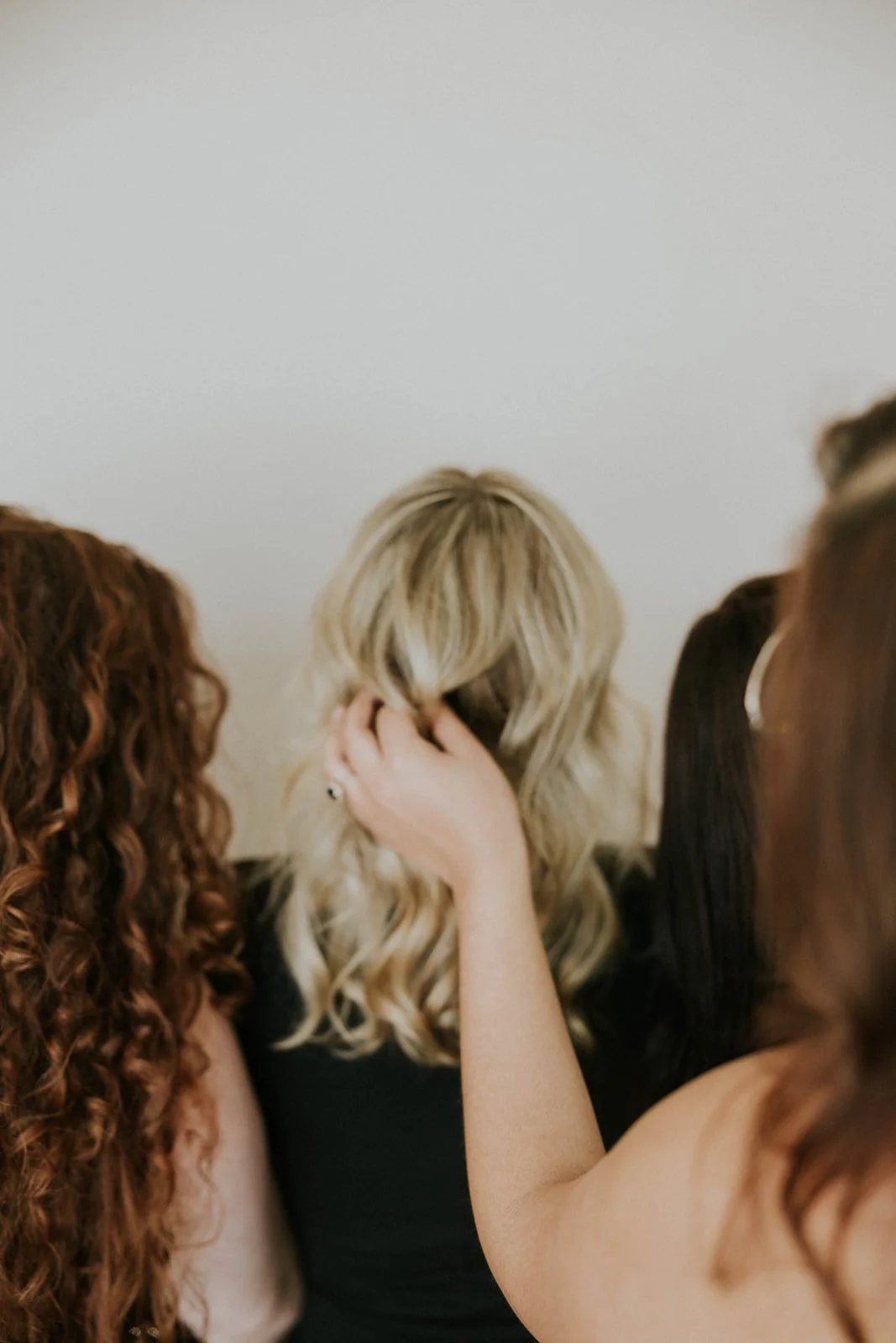 hair stylist fixing client's hair from the back