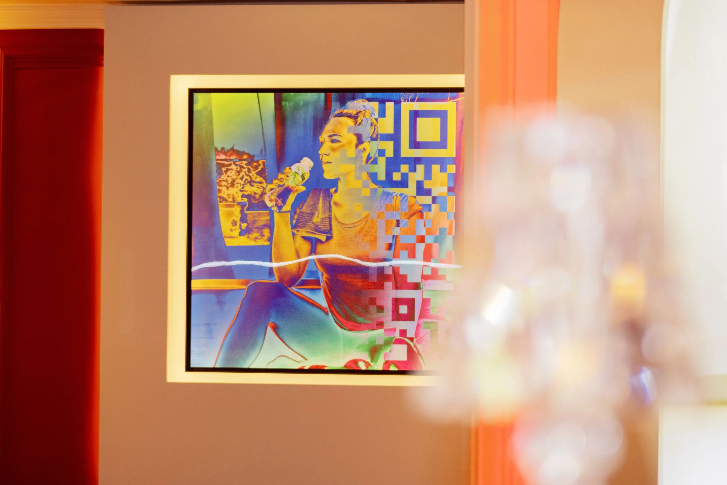 Une œuvre d'art numérique représentant une femme assise en train de boire une bouteille, avec des motifs en QR code et des couleurs vives.
