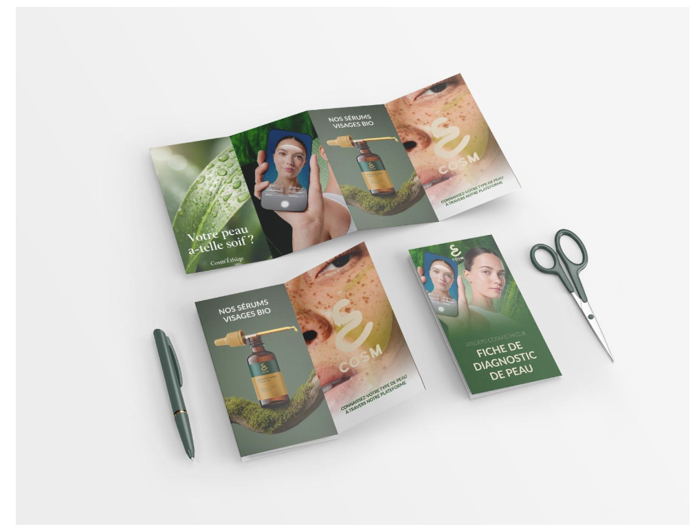 Différents matériels de brochures et de papeterie pour un produit cosmétique bio, avec des ciseaux, un stylo et un dépliant ouvert.