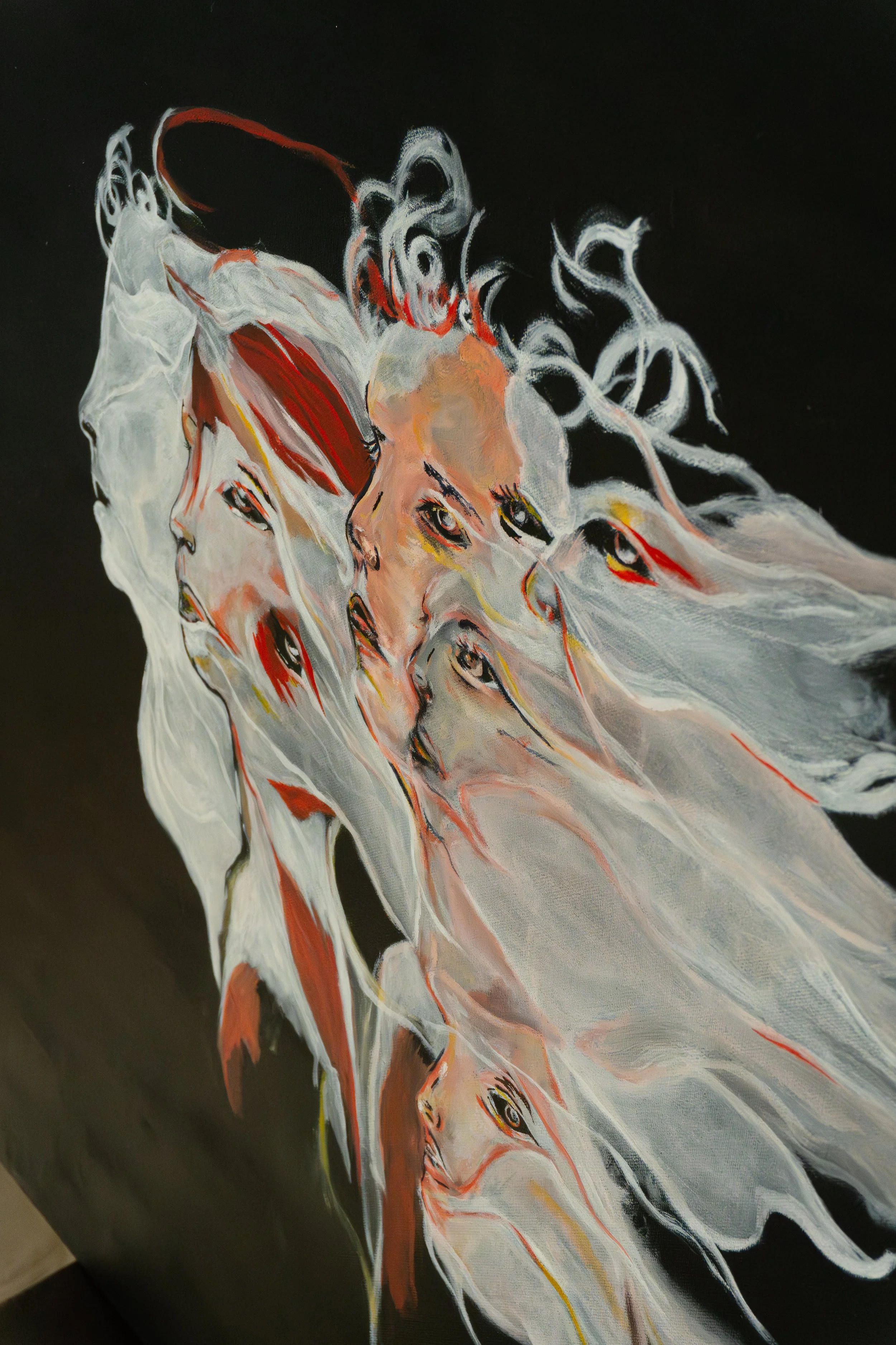 Une peinture abstraite représentant plusieurs visages féminins en couleurs sur un fond noir.