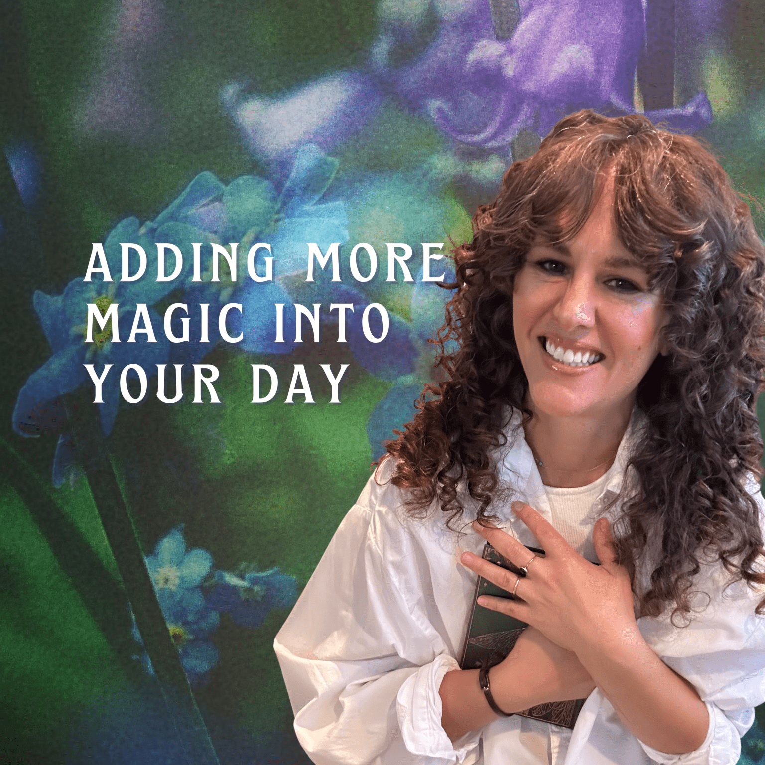 A woman with curly hair smiling and holding her hands over her chest, standing in front of a colorful floral background with the text "Adding More Magic Into Your Day."