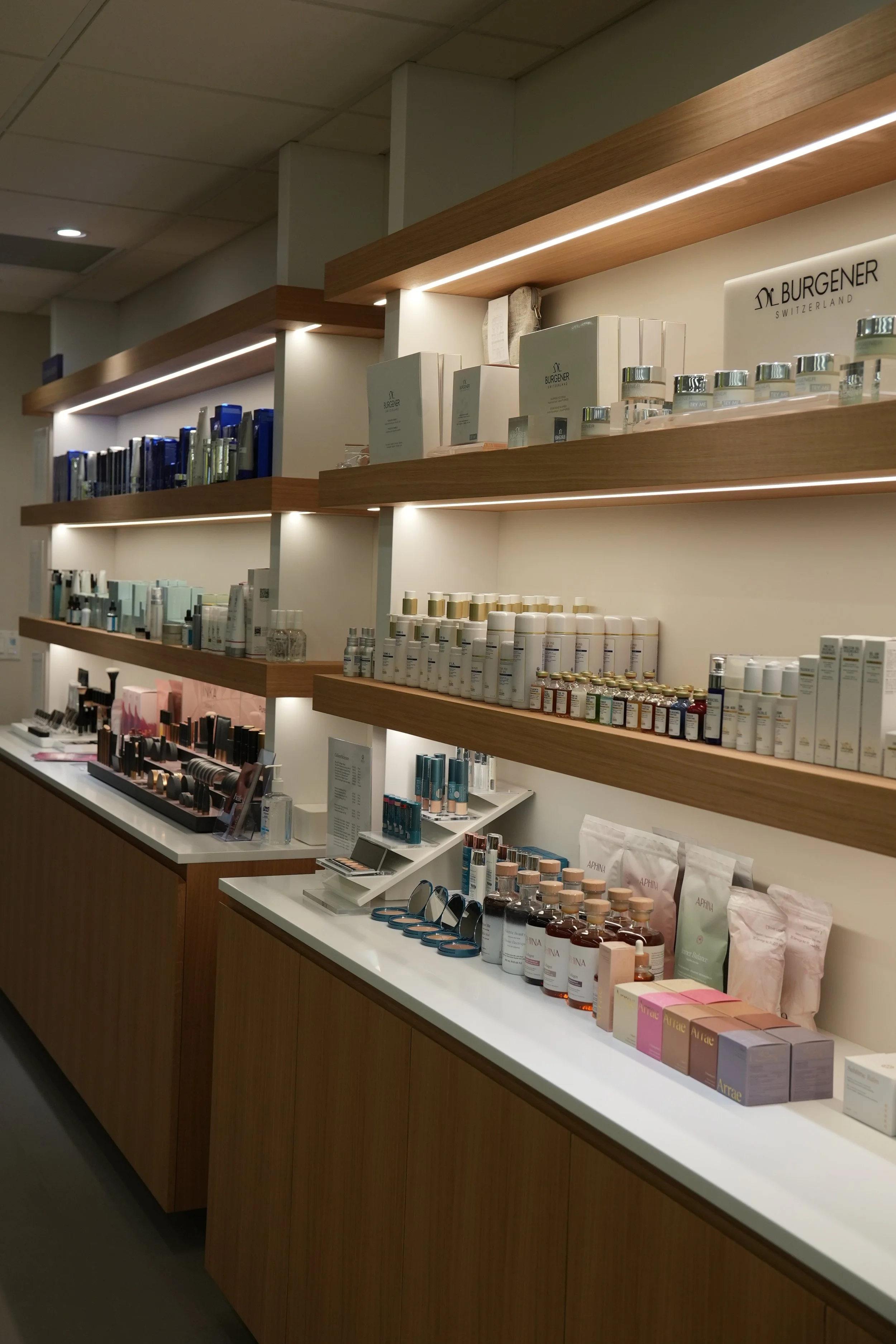 Elegant front desk at the 8West wellness clinic North Vancouver, highlighted by organized product shelving displaying vitamins, IV nutrients, and holistic health items. In the background, catch a peek of our bespoke IV lounge designed for ultimate re