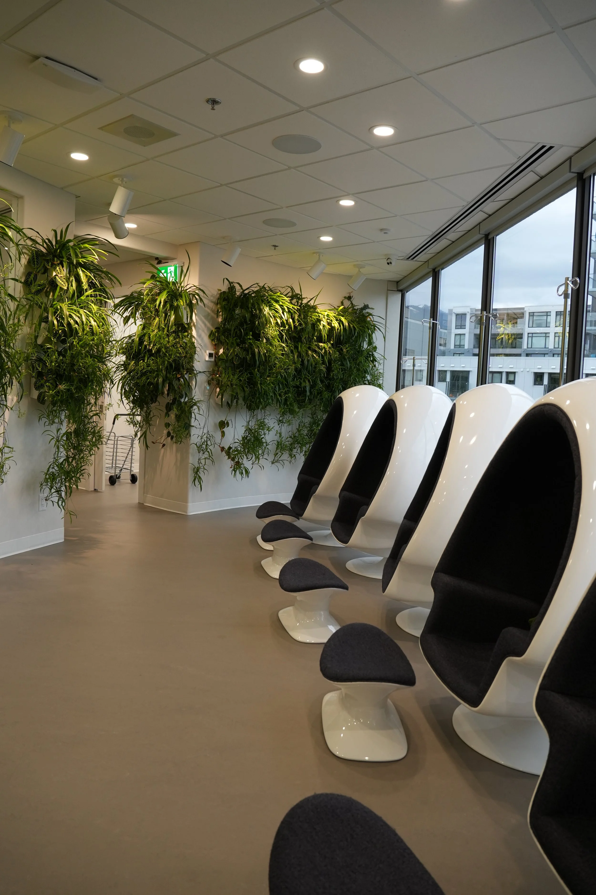 Clinic reception area at 8West North Vancouver showing custom product shelving with wellness supplements and view into luxurious IV lounge