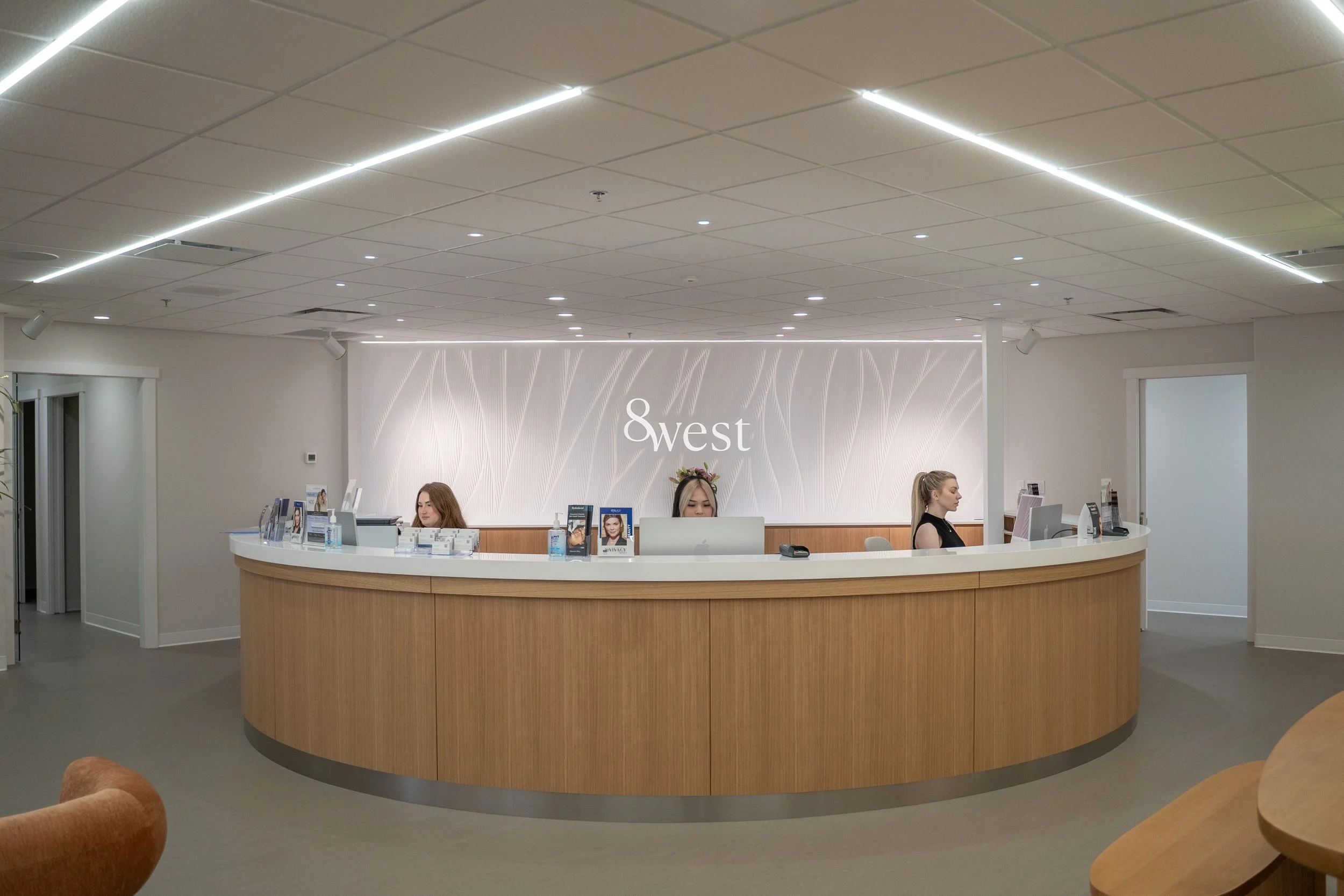 Modern welcoming front desk with branded signage and natural wood accents at 8West wellness clinic in North Vancouver