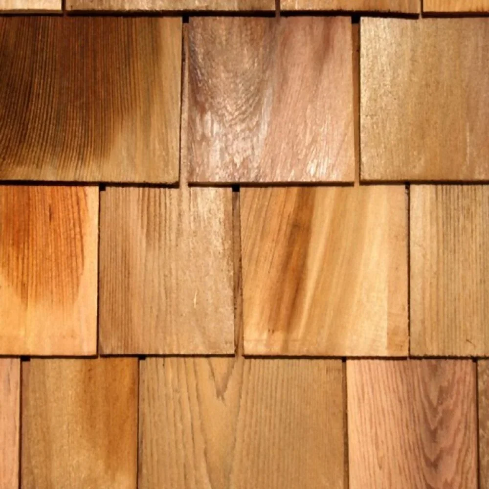 Close-up of a wooden shingle wall with square-shaped shingles arranged in a grid pattern.