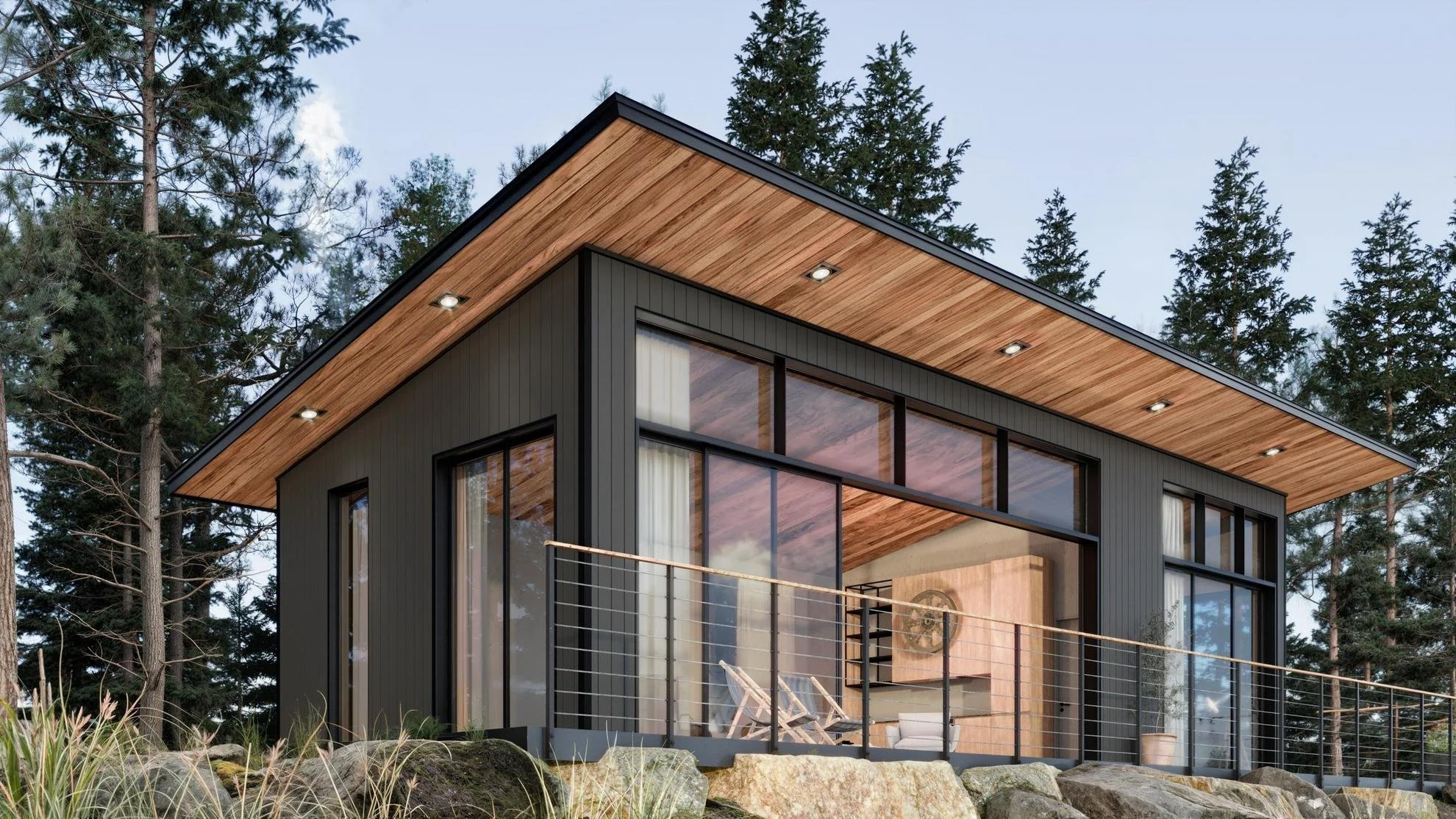 Modern black house with large glass windows and a wooden roof in a forested area with trees and rocks.