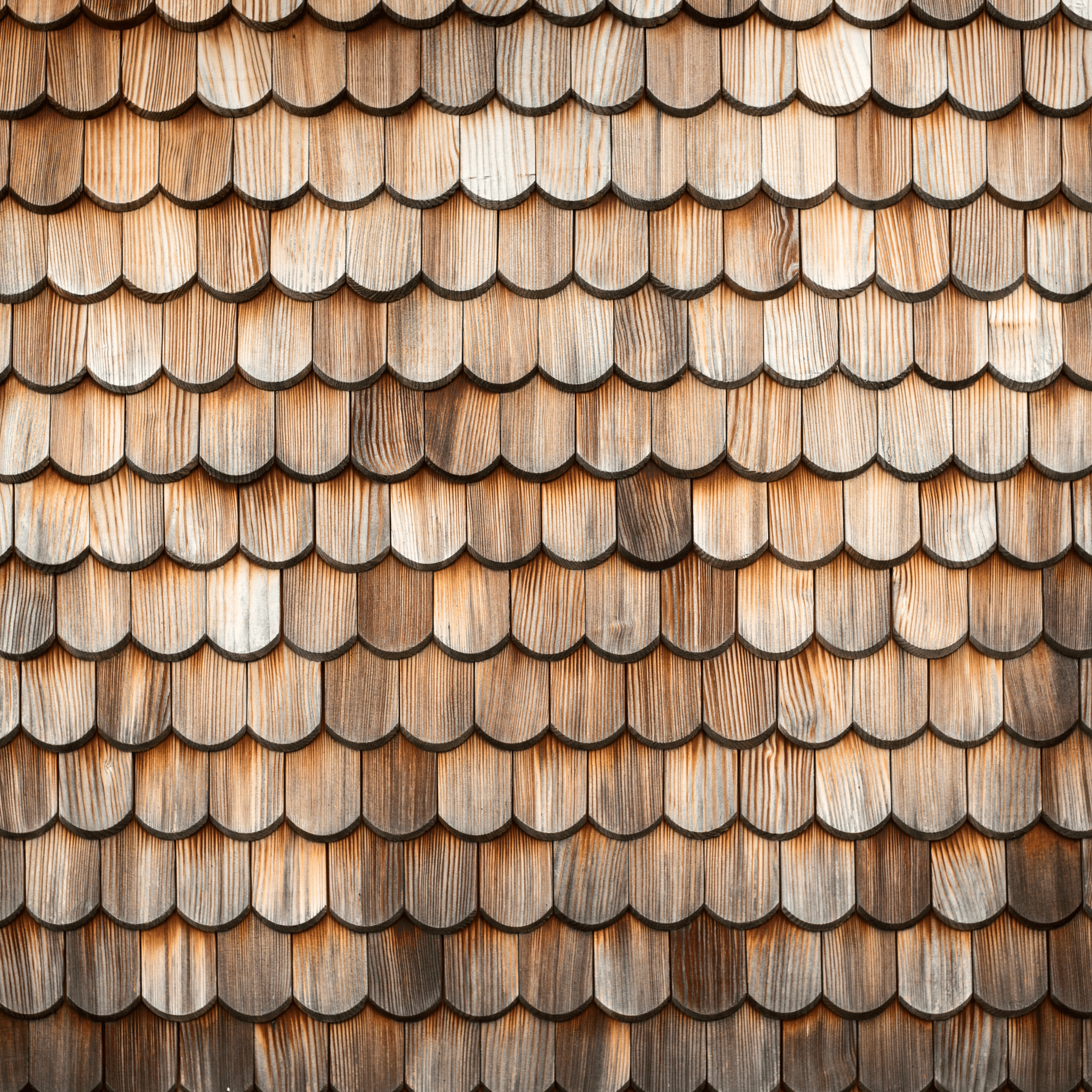 Close-up of wooden shingles arranged in overlapping pattern on building exterior.