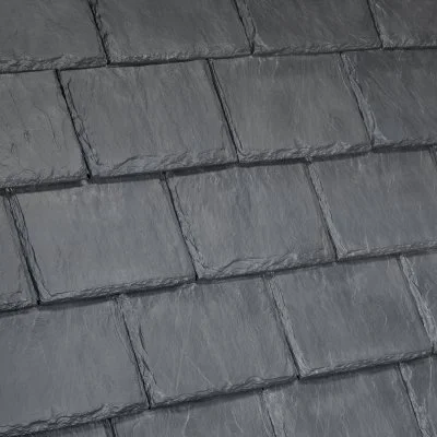 Close-up of a gray slate shingle roof with overlapping rectangular tiles.