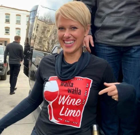 Woman smiling and pointing to her Wine Limo shirt. 