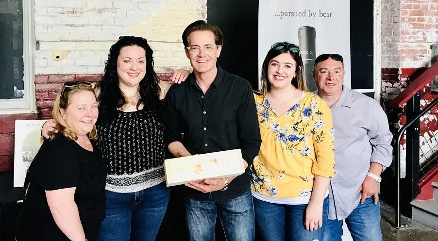 Wine tour group poses with Kyle McLachlan, owner of Pursued by Bear Winery. 