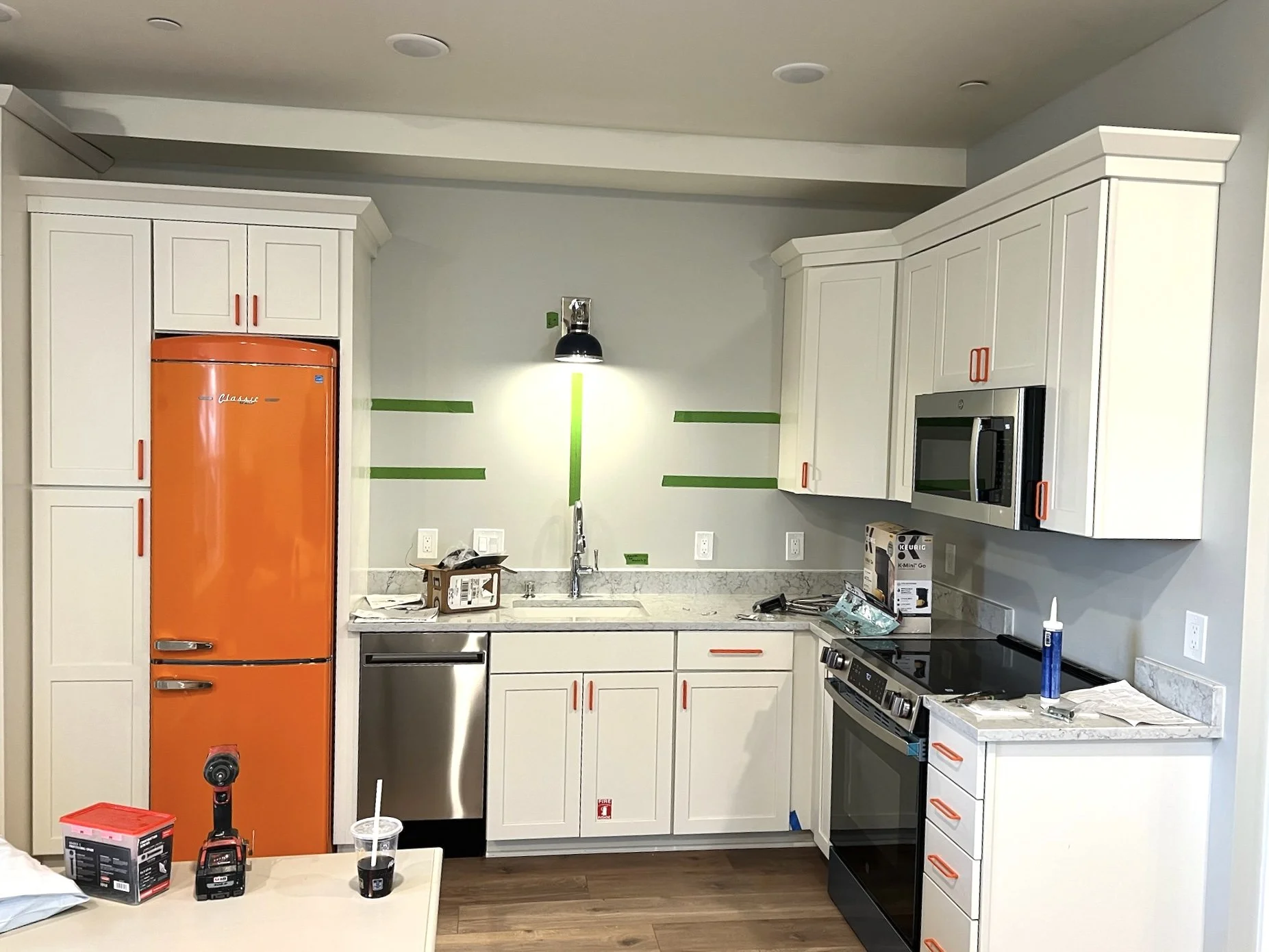 Orange refrigerator in clean white kitchen