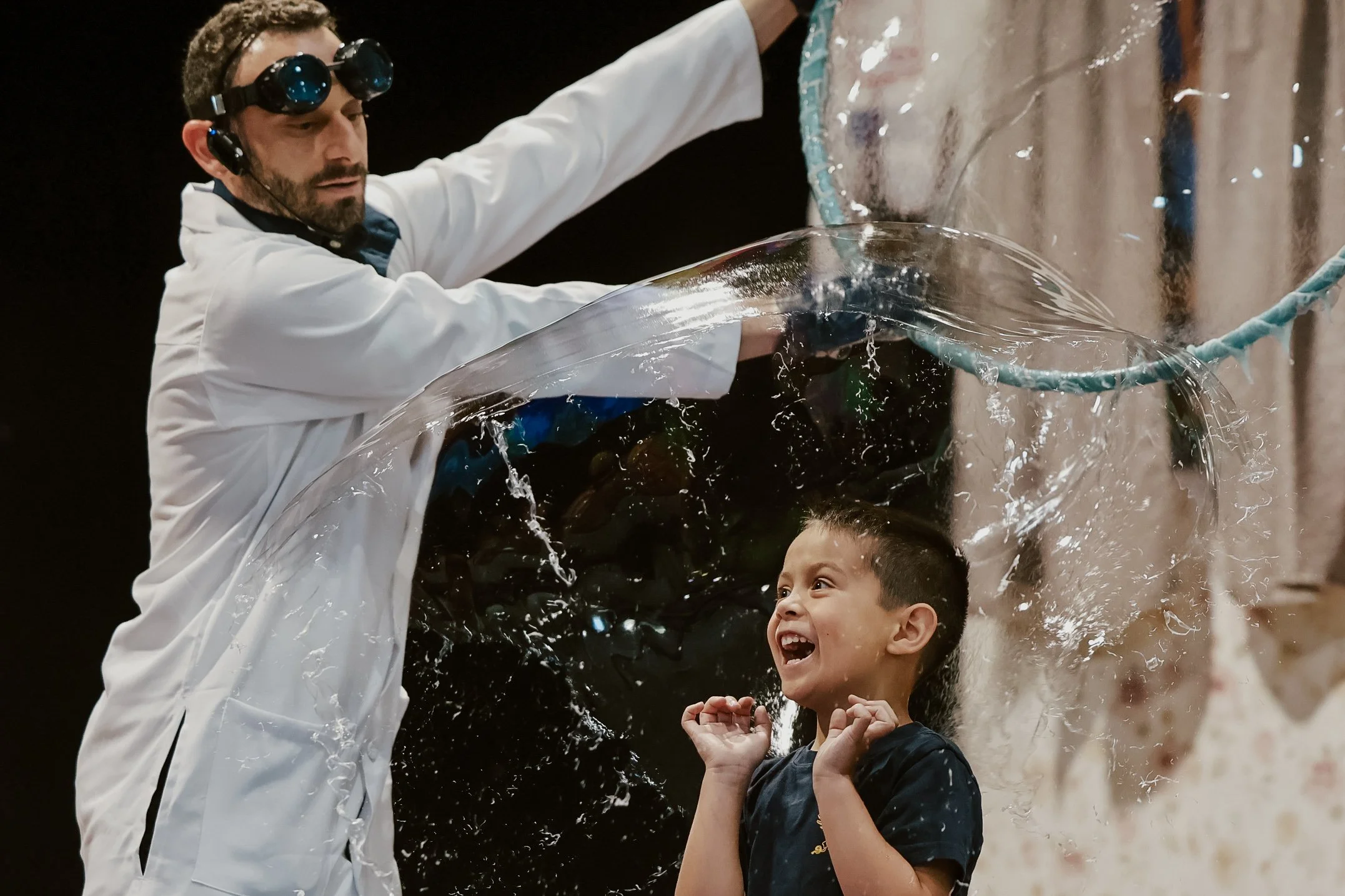 Student inside a giant bubble during an IncrediBubble STEM assembly show at a Colorado school