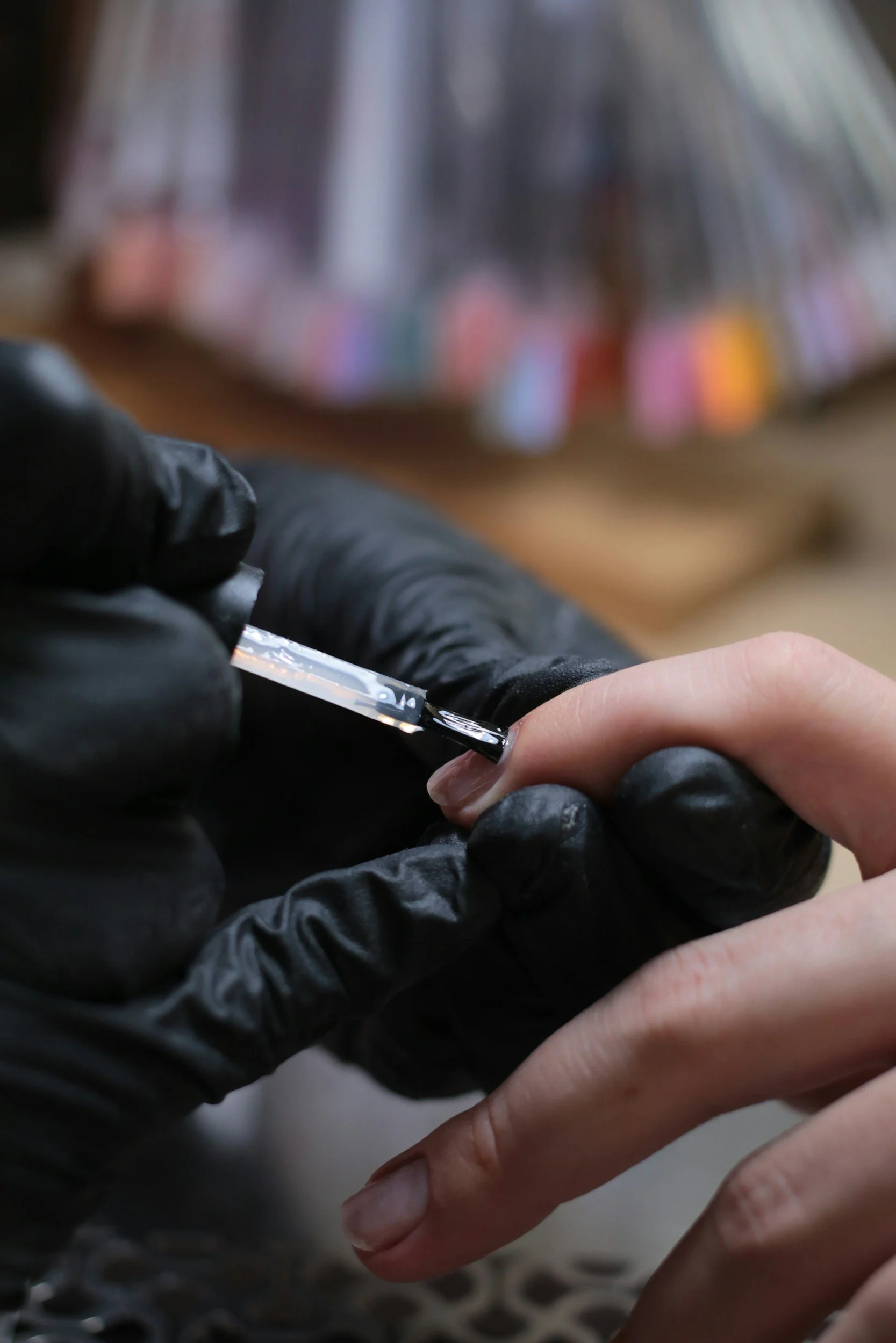 Close-up of a person's hand receiving a vaccination shot from a healthcare worker wearing black gloves.