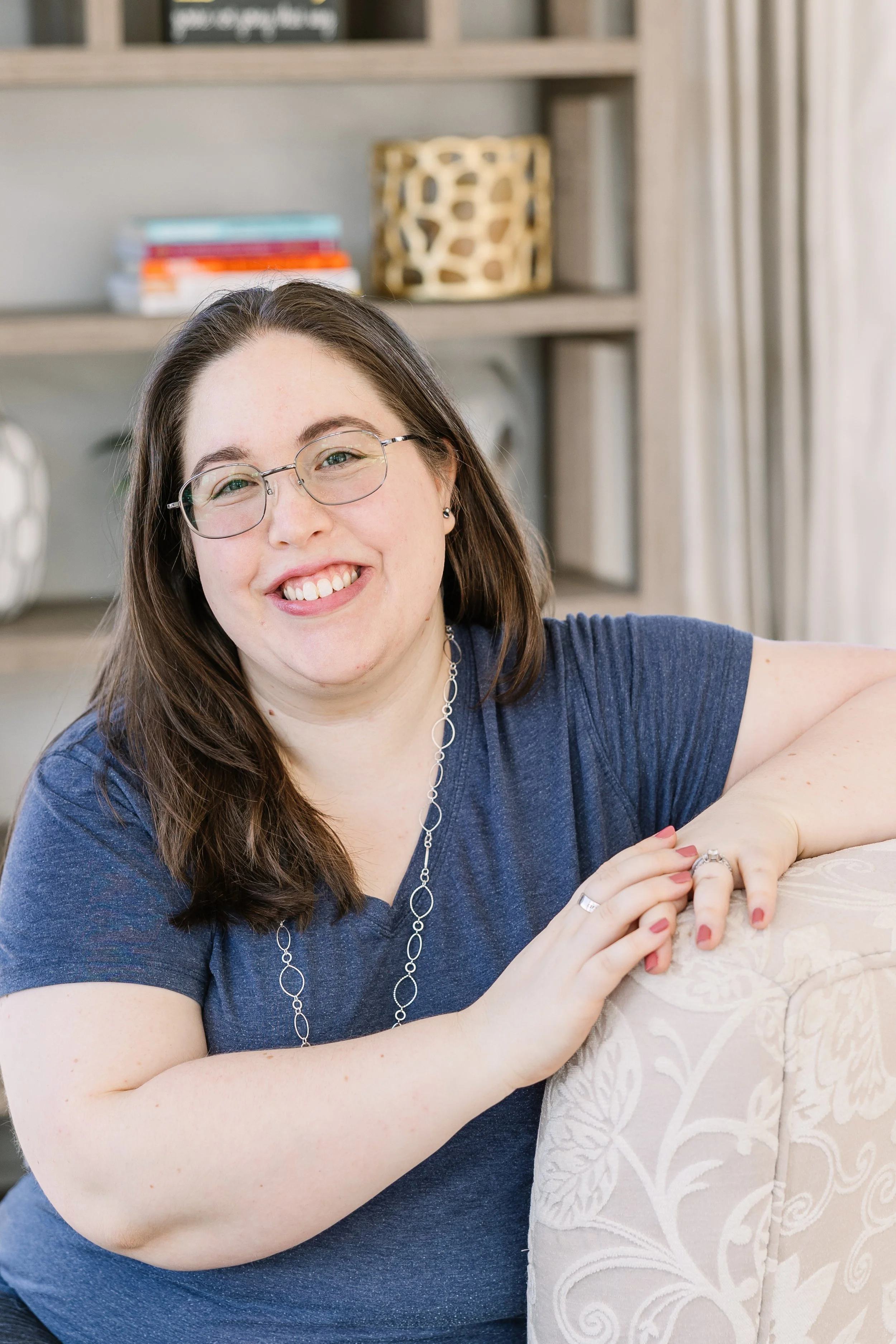 Professional speaker Sarah LaFontaine smiling sitting on an armchair