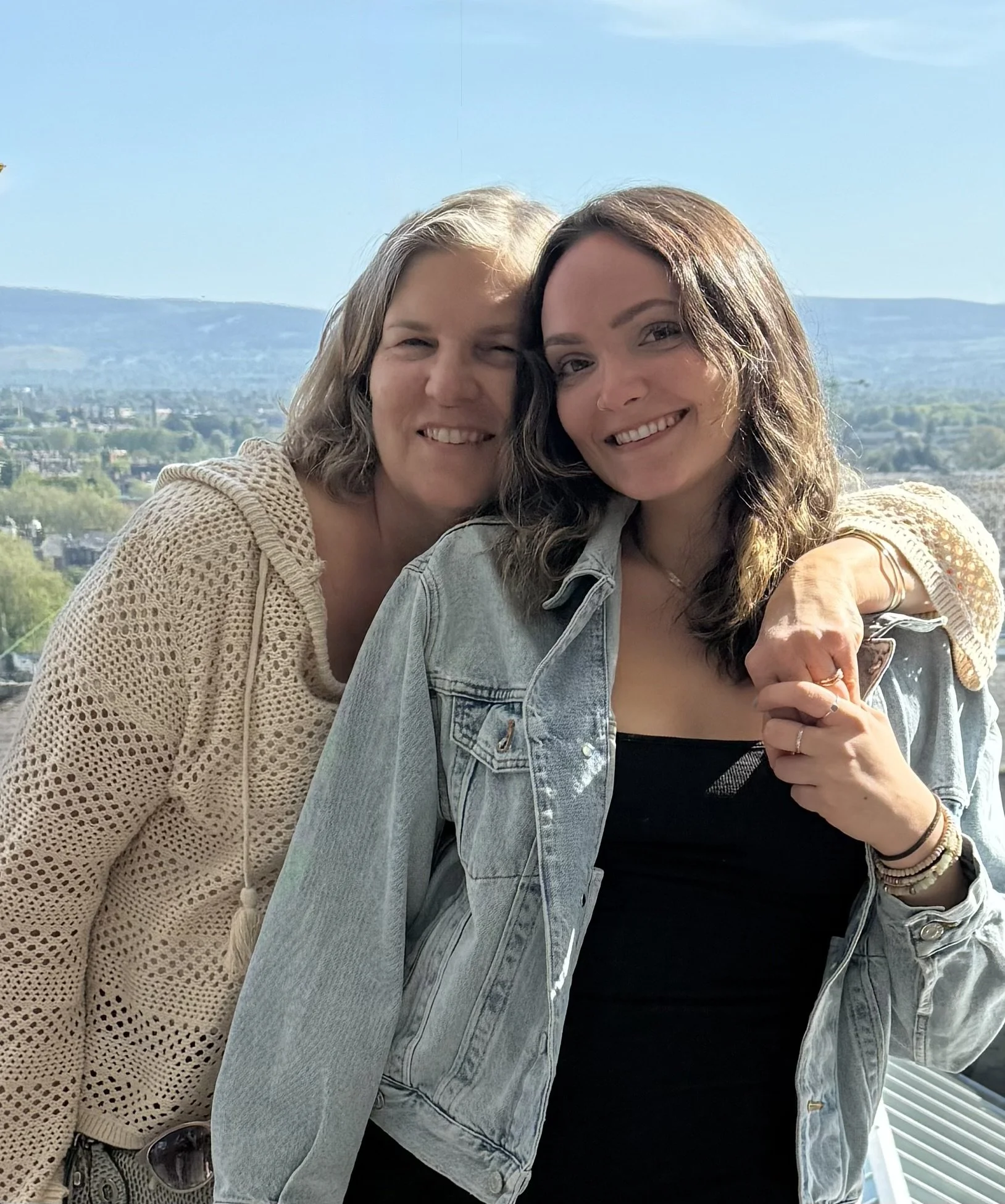 Lisa Martin with Meghan, the illustrator of Our Healing Home, smiling outdoors with a mountain view.