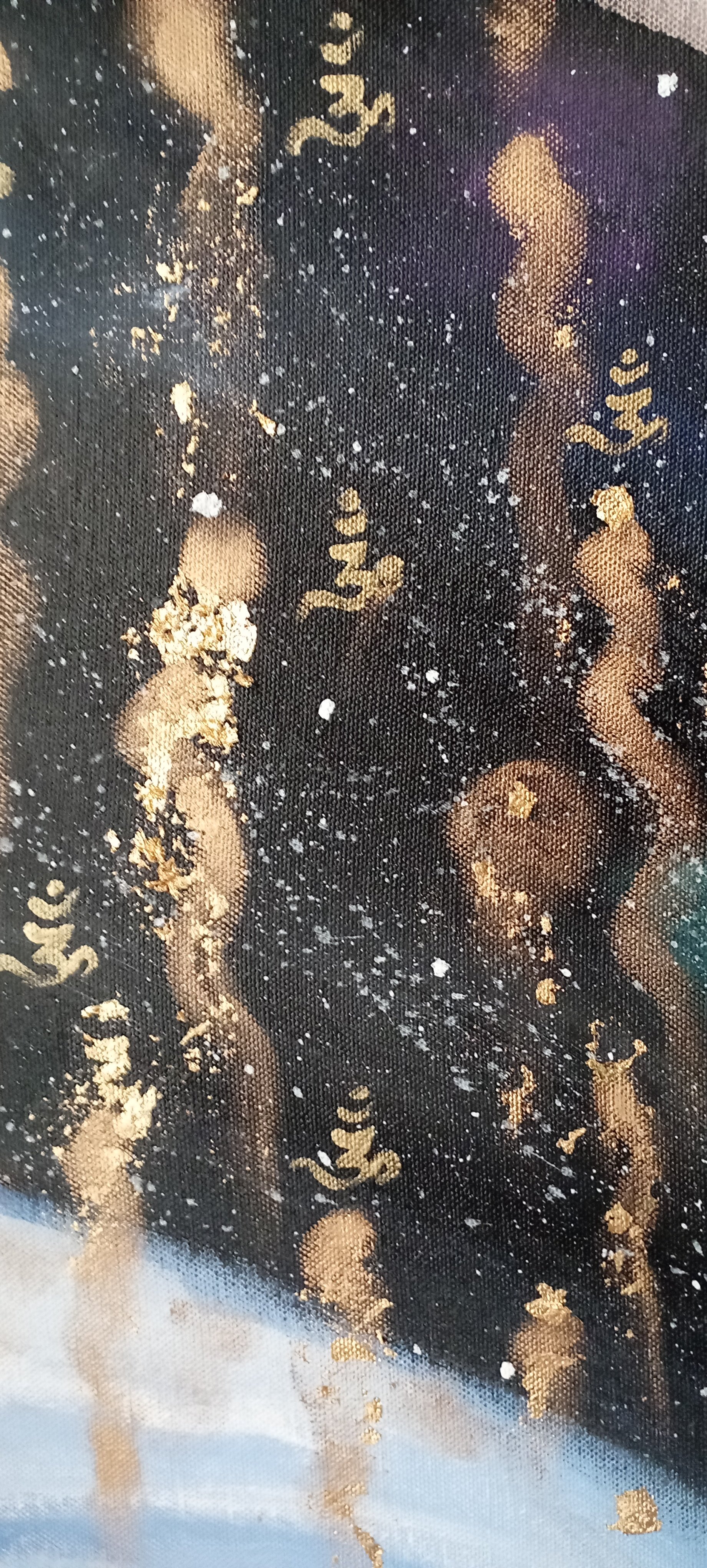 Close-up of fabric with a black background, gold Japanese characters, and gold paint splatters or spots.