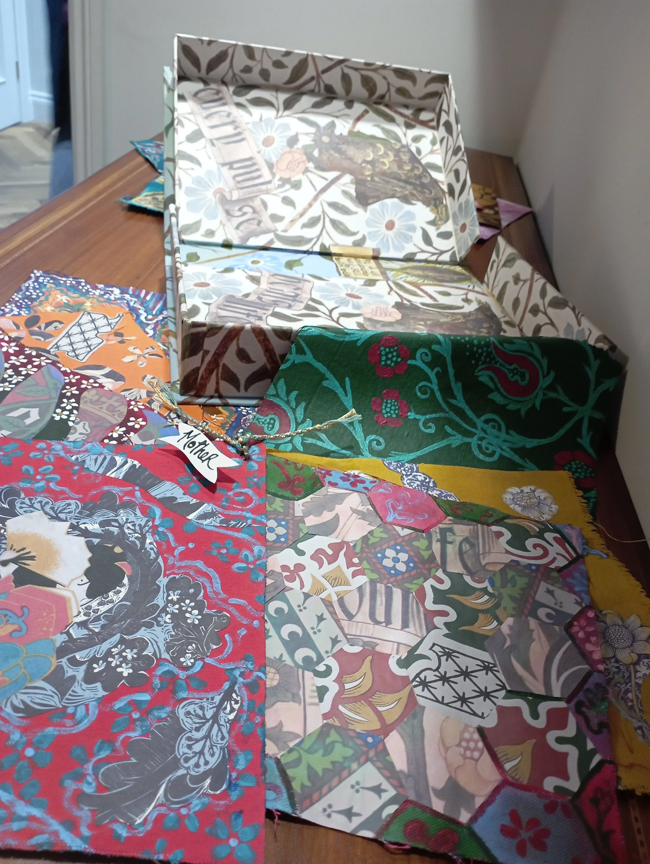 Assorted colorful fabric swatches and a decorative box on a wooden table.