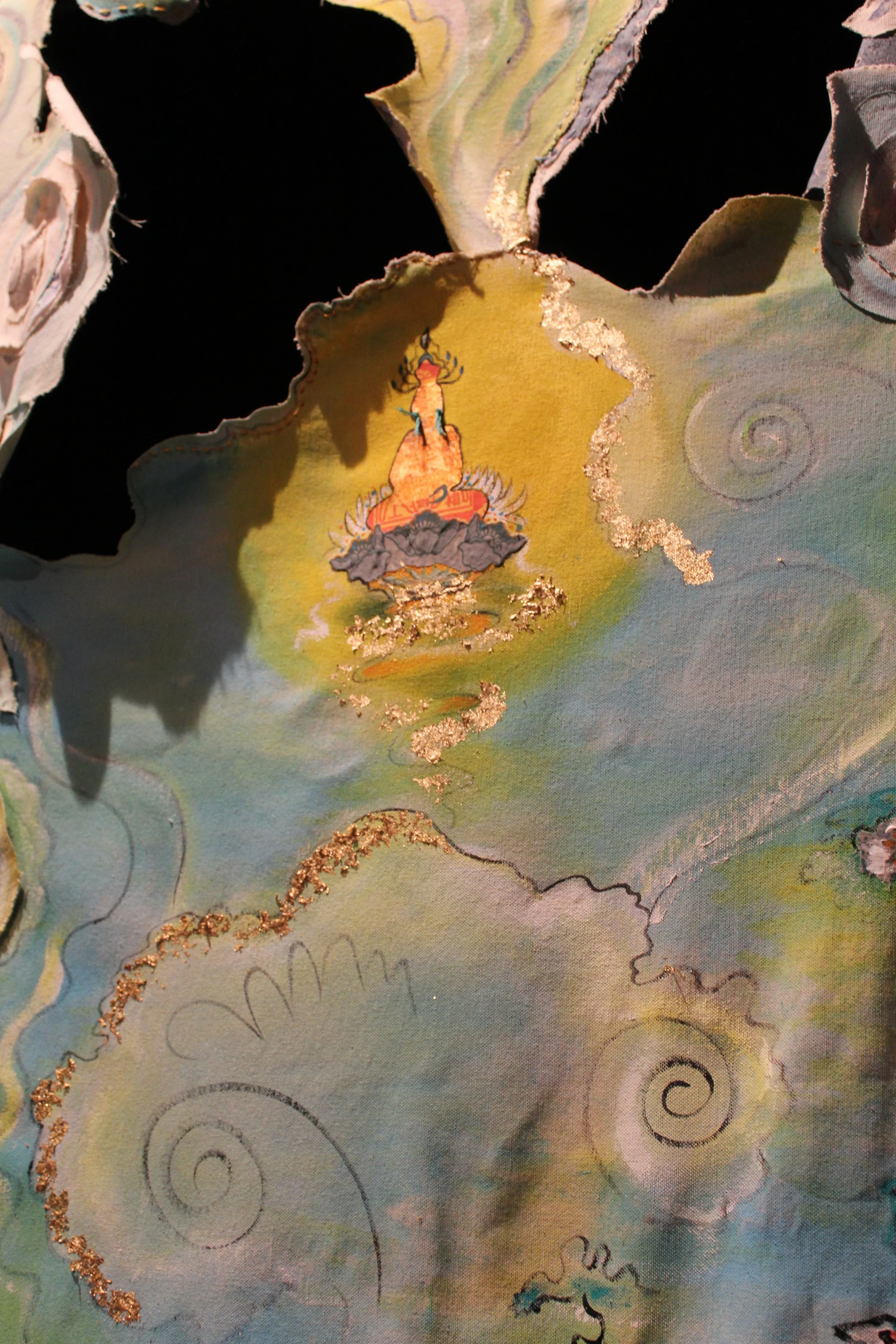 Close-up of a decorative, painted paper with swirling patterns and a colorful, stylized depiction of a lotus flower with gold accents.