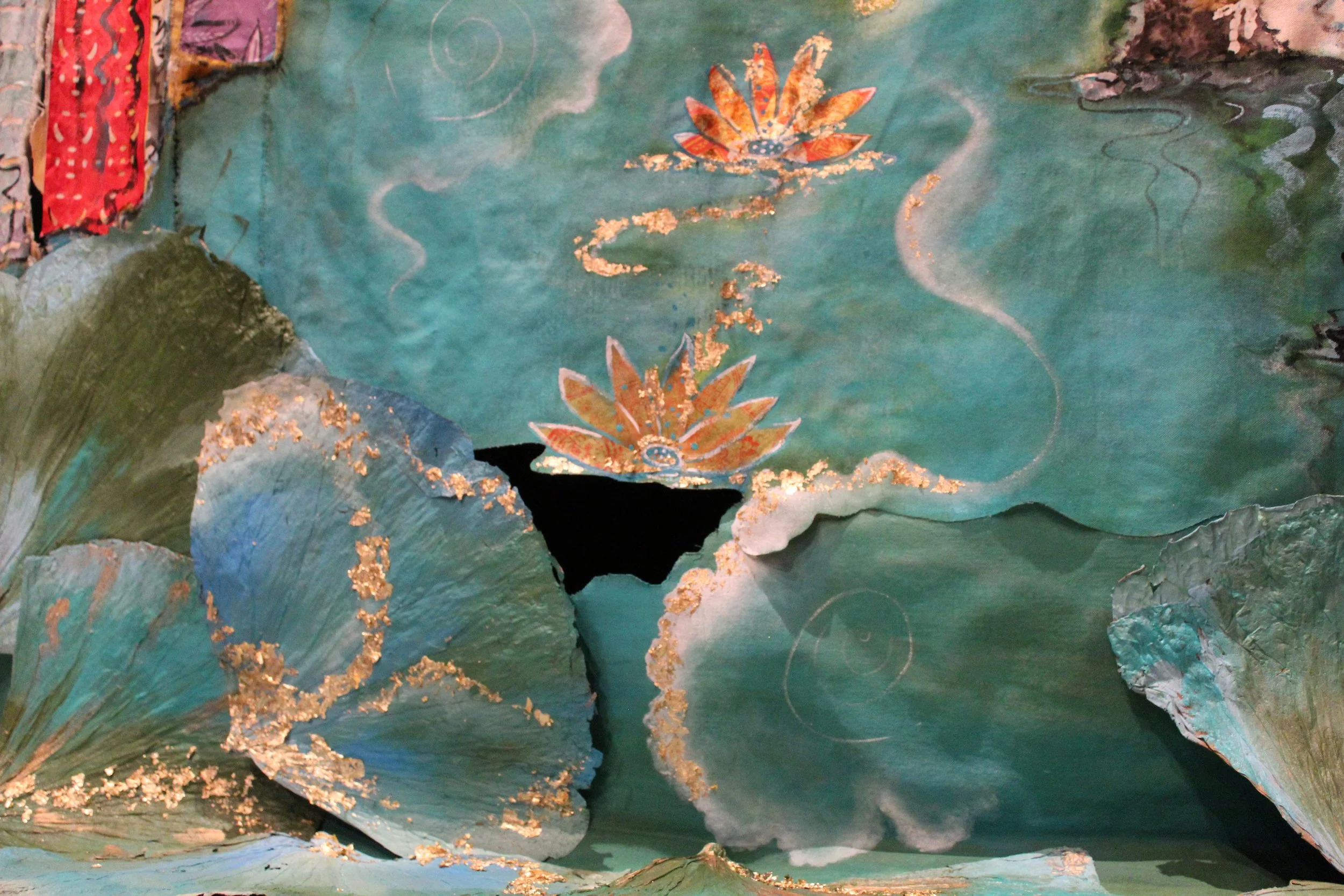 A decorative artwork featuring a teal and green background with lotus flowers and gold accents. The scene includes layered textured leaves and flowers, with swirling lines and delicate gold detailing.