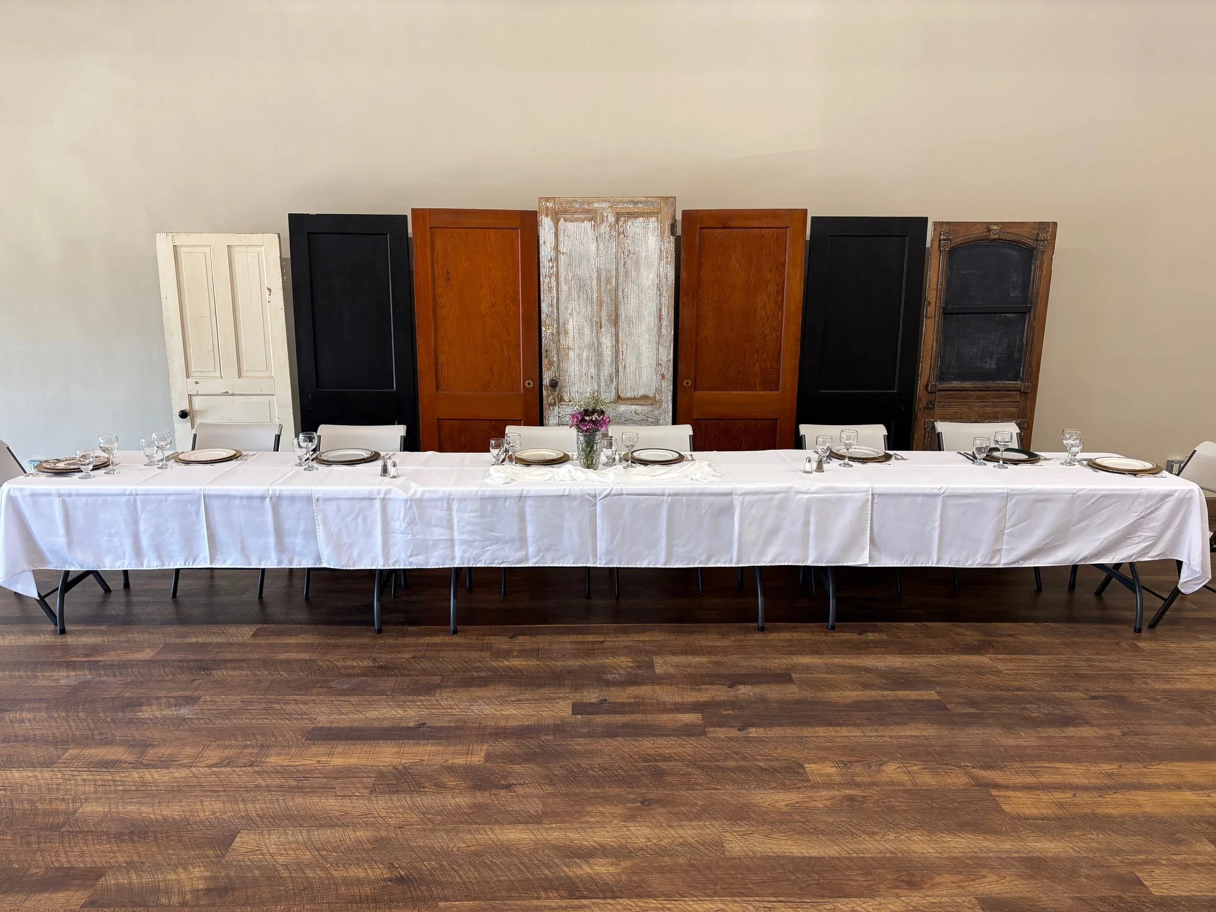 Event space that provides white tables, table linens and decorative doors for your event rental.