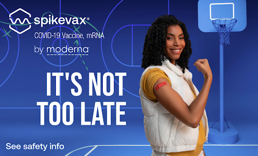 A smiling woman with curly hair flexing her arm in front of a COVID-19 vaccination advertisement for Spikevax by Moderna. The background features a basketball hoop and a blue design.