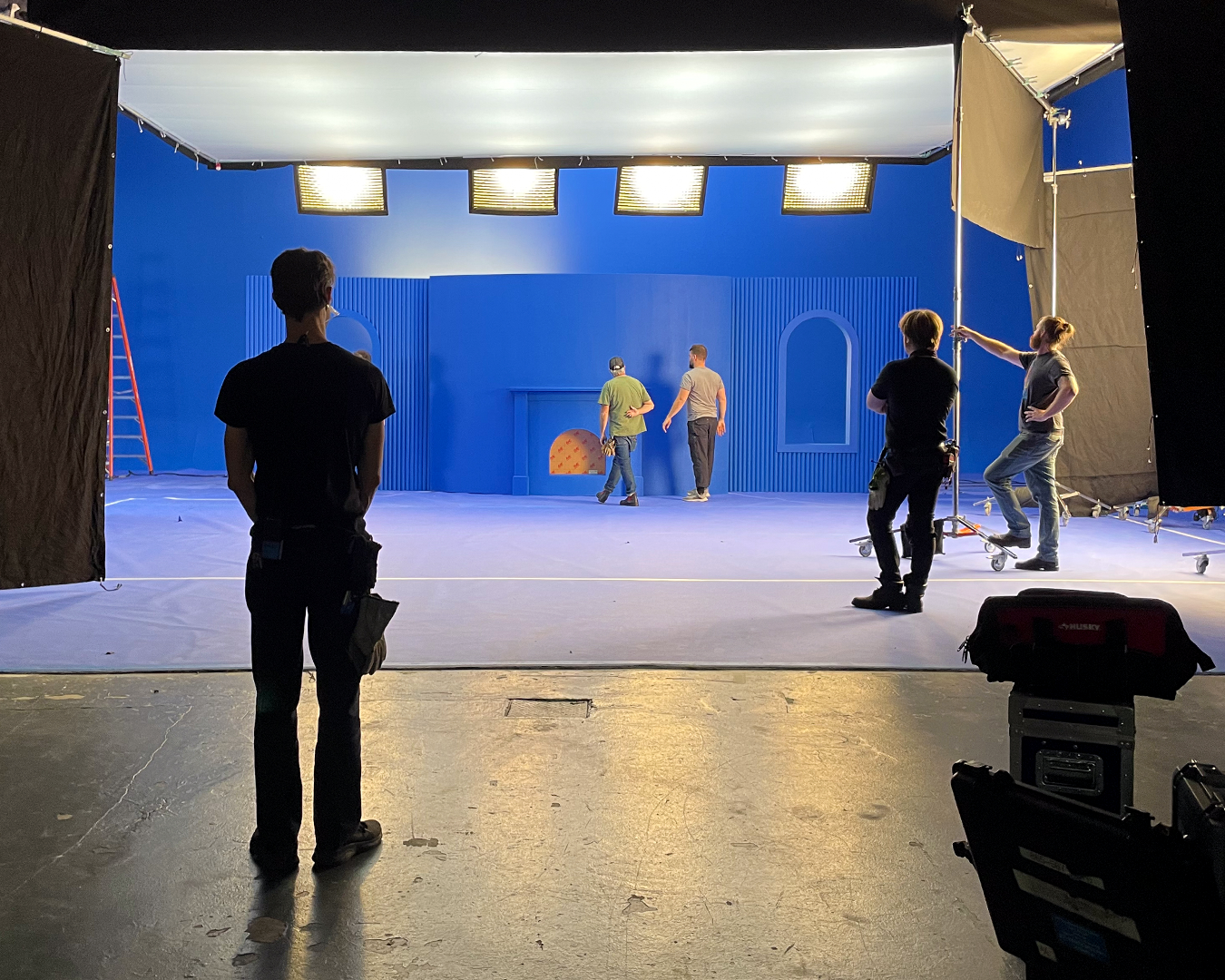 SET DESIGN:
Surreal-ish sets embody the living room home with a symmetrical fireplace,  sculptural Christmas Tree and  big snowy windows. The minimalist, monochromatic space proved the perfect backdrop for our vibrant wardrobe and larger than life ch