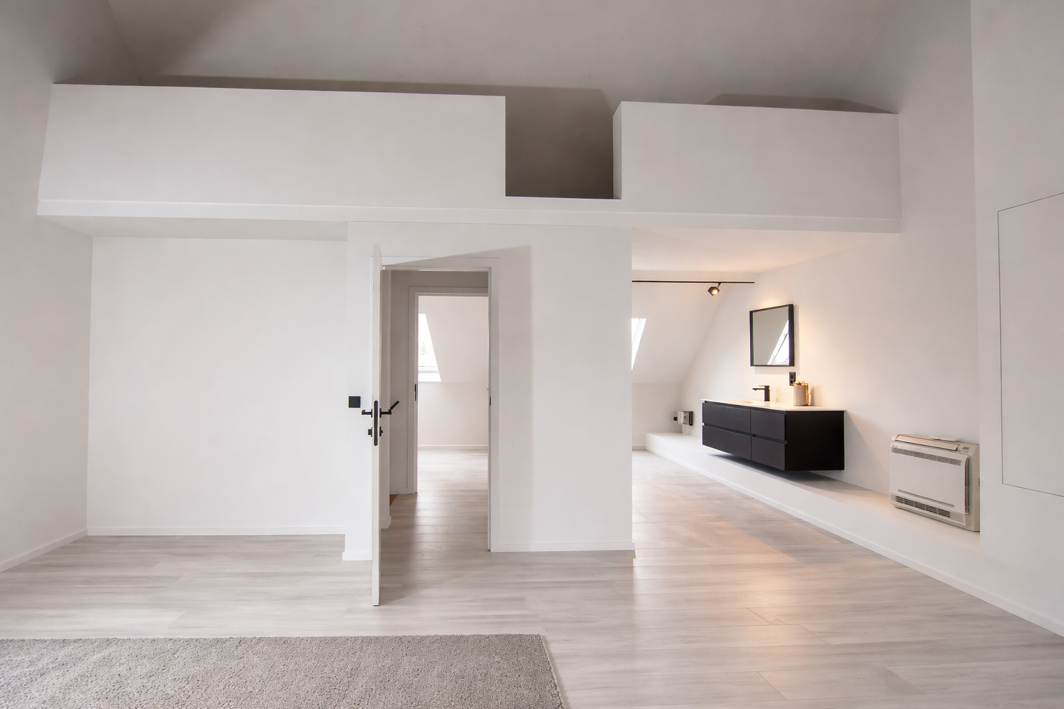 Moderne minimalistische slaapkamer met witte muren, een lichte houten vloer en een zwarte ladekast met een spiegel erboven.