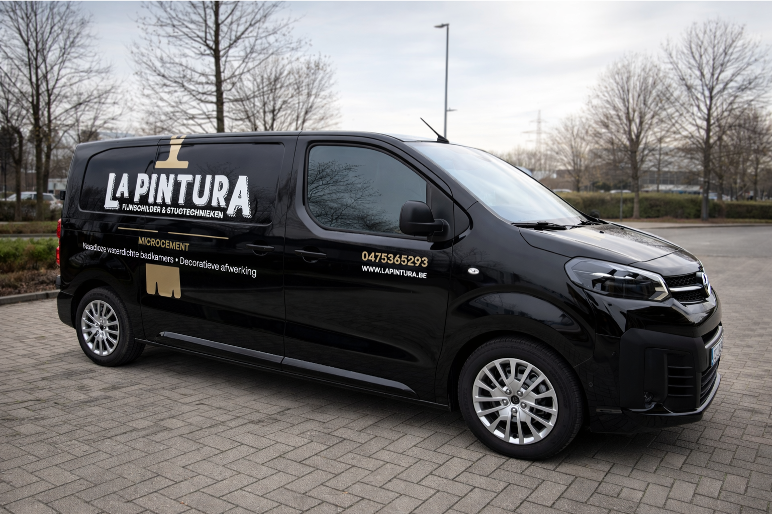 Black commercial van parked on paved area, advertising La Pintura, a painting and decorating company, with contact info and website.