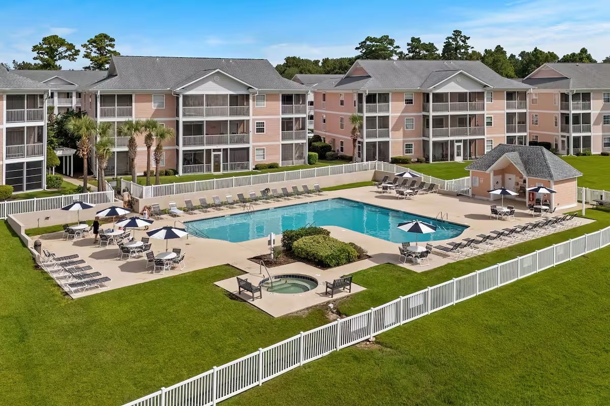 Community swimming pool with shared outdoor seating and umbrellas at Waterway Village Condos, a Myrtle Beach SC rental community.