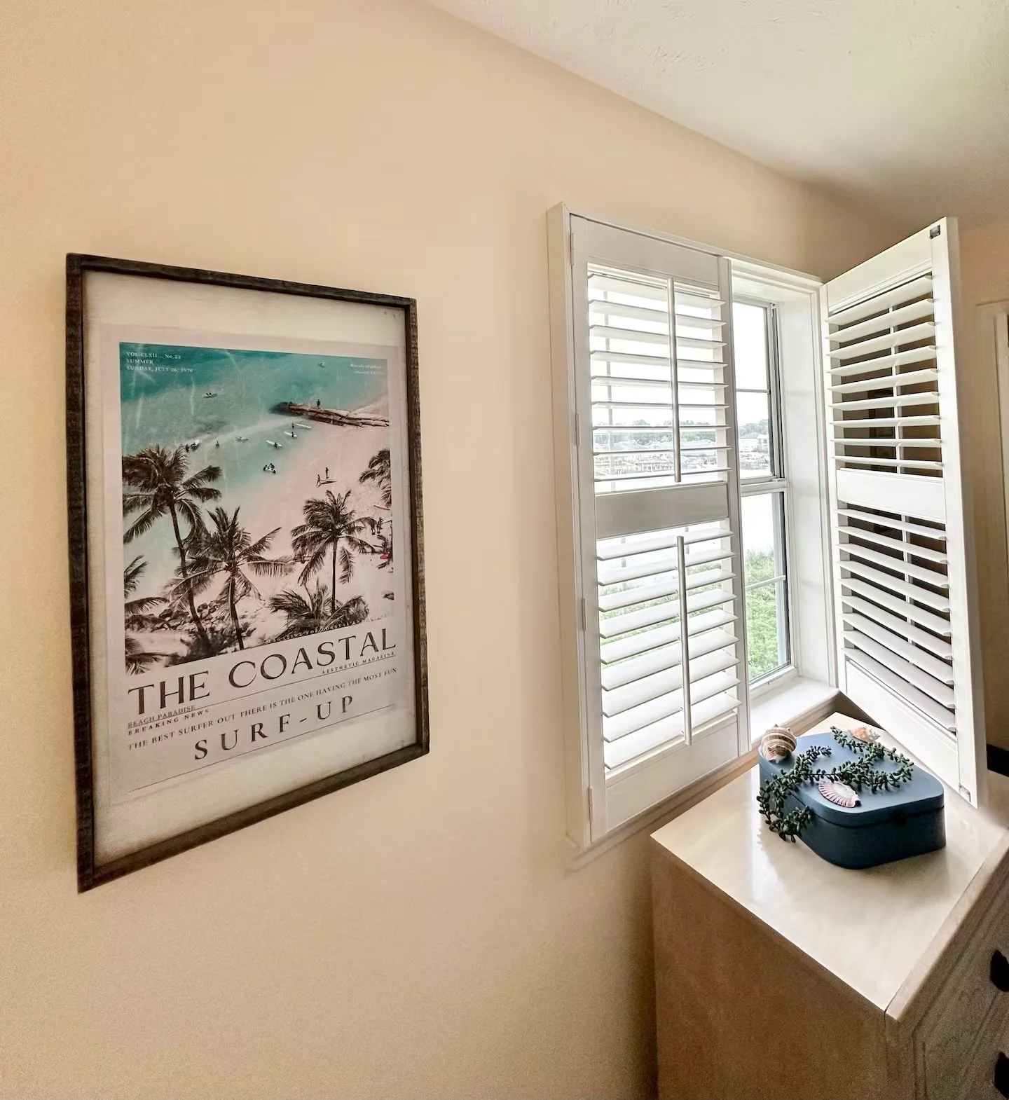 Beach-inspired room decor in a Myrtle Beach SC rental condo at Waterway Village with framed coastal art, open shutters, and styled dresser.