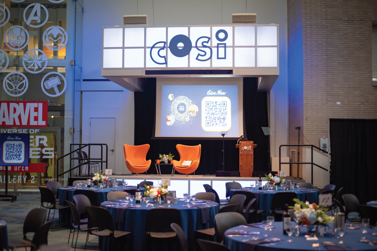 Orange and blue vibrant corporate event set up for a luncheon and fireside chat