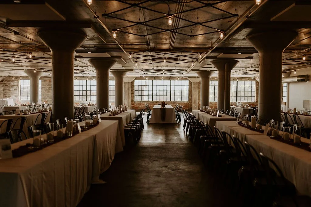Dark and mood wedding reception set up with monochrome earthy tones in an industrial venue