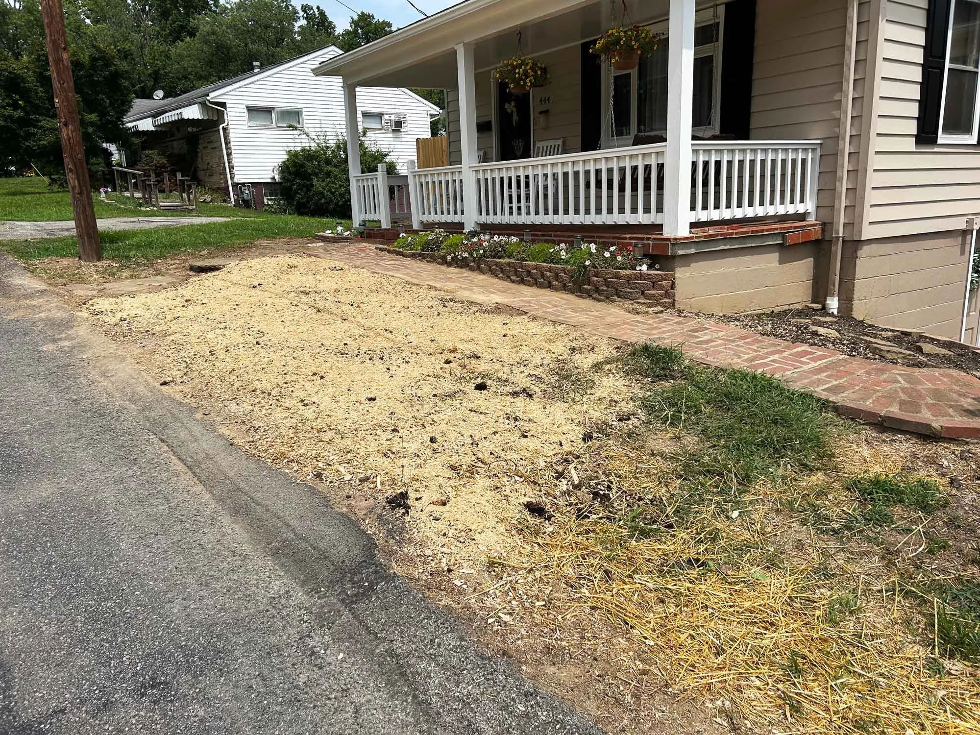 Front yard after stump grinding with tree stump removed and ground leveled for lawn restoration.