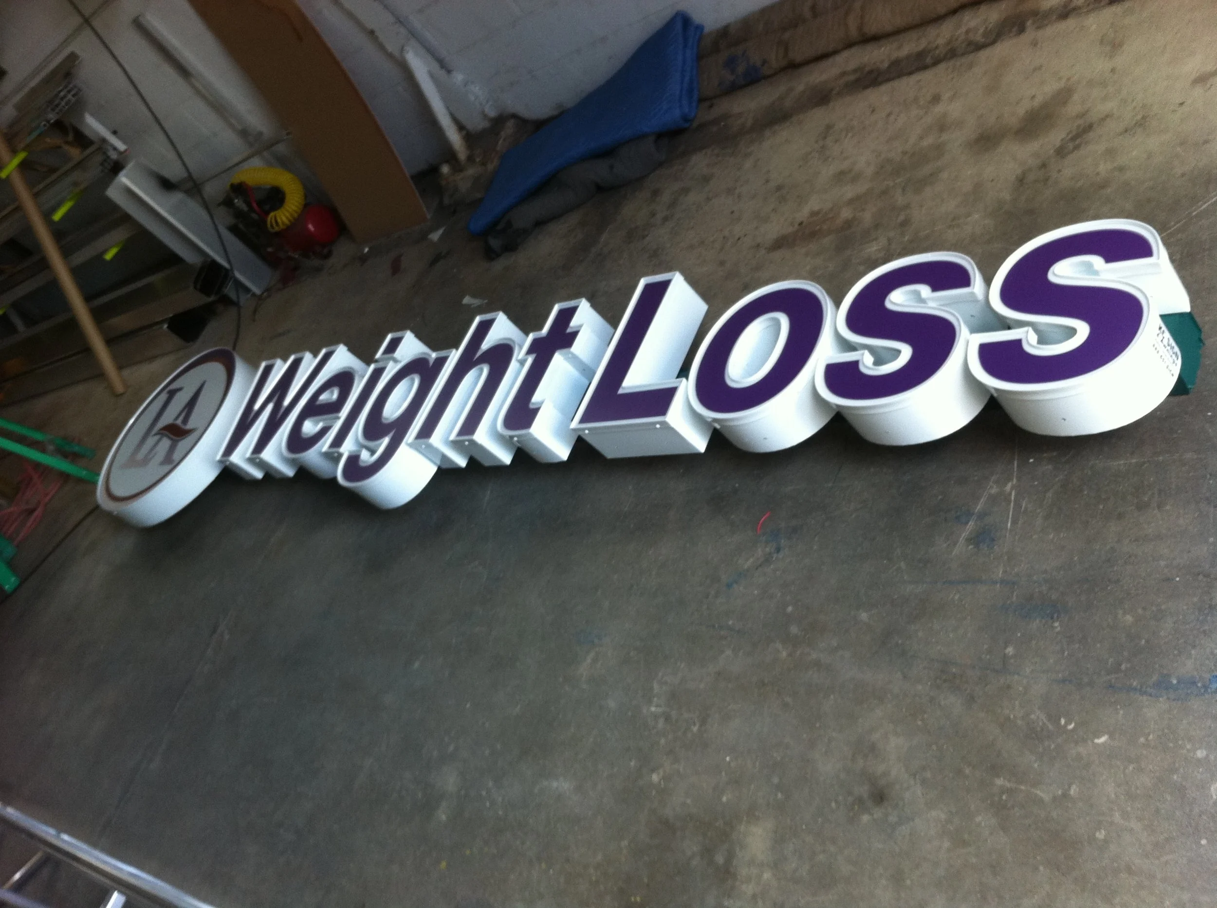 A large illuminated Walmart logo sign on the floor in a workshop or storage room.