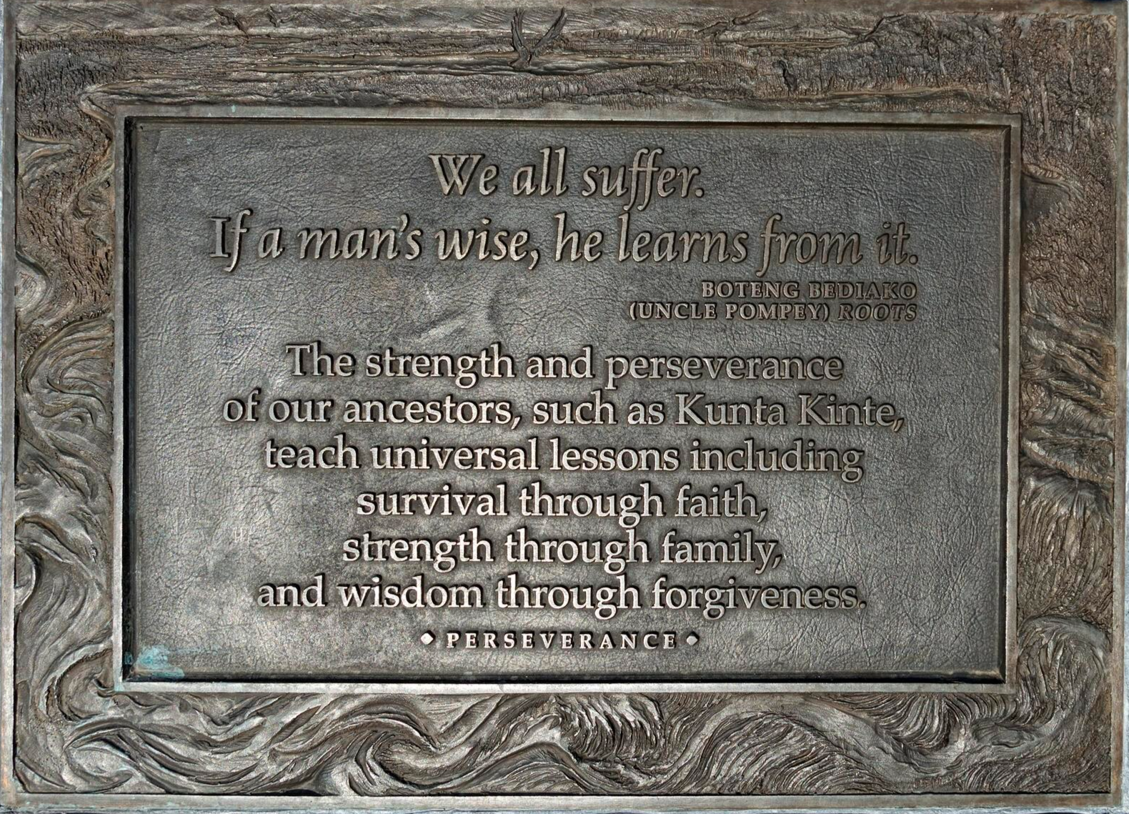 Bronze plaque with an inspirational quote about perseverance, attributed to Boteng Bediako (Uncle Pompey) Roots, emphasizing strength, perseverance, faith, family, and forgiveness.